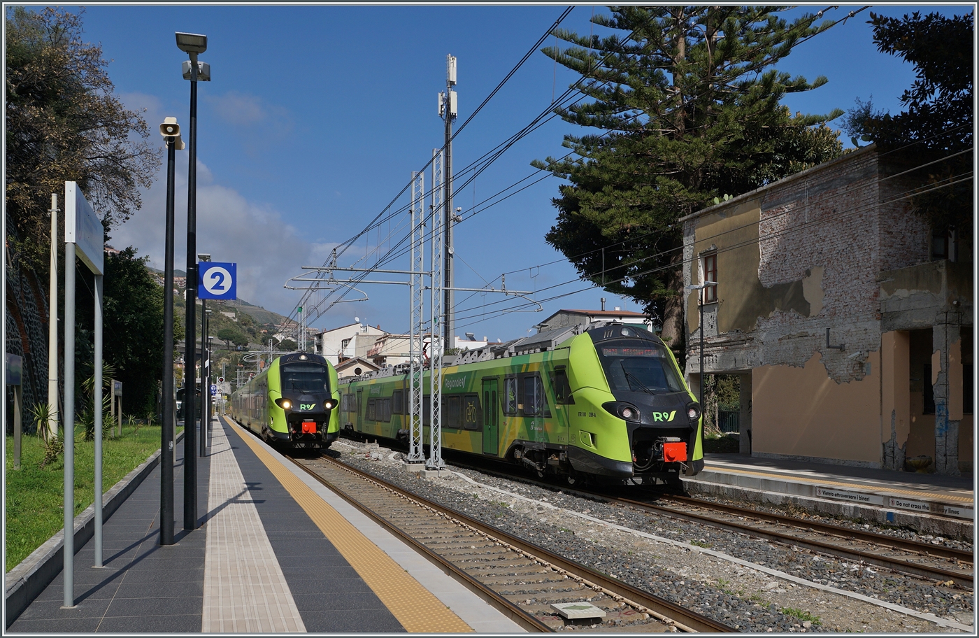 Der FS Trenitalia Coradia Stream Pop ETR 104 278, rechts im Bild, unterwegs als Regionalzug 12978 von Catania nach Messina hat Letojanni erreicht, w�hrend der FS Trenitalia ETR 104 278 als RE 5395 auf der Fahrt von Messina nach Siracusa ohne Halt durch den Bahnhof f�hrt. Beide Triebz�ge zeigen sich in den neuen FS Trenitalia Regionalzugfarben.

11. M�rz 2026 