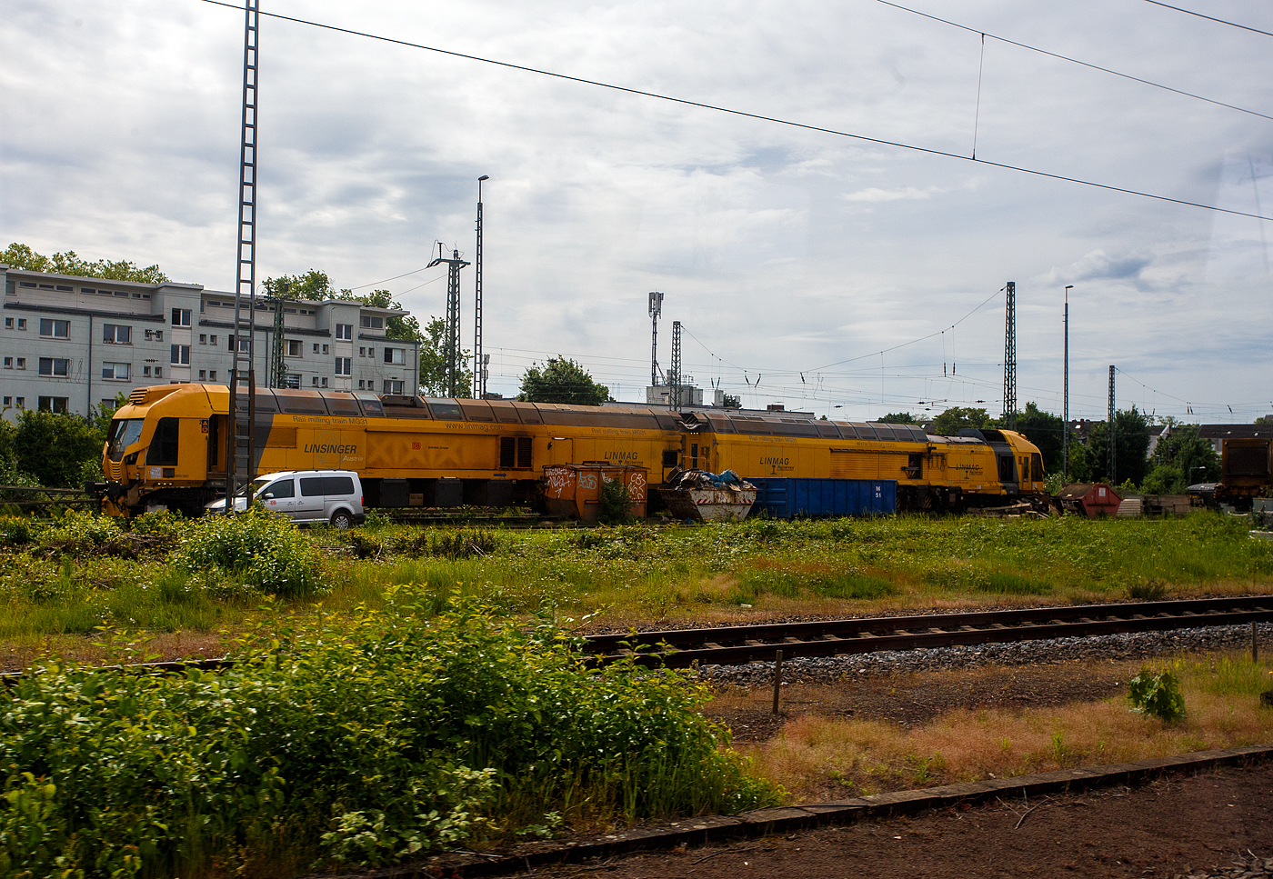 Der LINSINGER Rail milling train MG31 (LINMAG Schienenfräszug MG 31), Schweres Nebenfahrzeug Nr. D-DB 99 80 9427 009-2, der DB Bahnbau Gruppe GmbH steht am 26 Mai 2024 in Opladen. Aufnahme aus einem Zug heraus.

Der Schienenfräszug MG 31 wurde 2012 von LINSINGER Austria Maschinenbau Ges. m.b.H. in Steyrermühl (Österreich) entwickelt und gebaut. Auf der InnoTrans 2012 wurde er erstmals der Öffentlichkeit vorgestellt.

TECHNISCHE DATEN:
Spurweite: 1.435 mm (Normalspur)
Achsanzahl: 24 (je 3 Achsen in 4 Drehgestelle)
Achsfolge: unbek.
Länge über Puffer: 23.800 mm/Einh. = 47.600 mm
Drehzapfenabstände: 15.300 mm
Eigengewicht: 183 t
Fahrantrieb:  hydraulisch
Leistung Hauptdieselmotor: 830 kW
Zur Mitfahrt zugel Personen: 5
Höchstgeschwindigkeit: 100 km/h
Zugelassen für Streckenklasse: CE und höher und CM4
Kleister befahrbarer Gleisradius: 150 m
Max. Streckeneigung: 40 ‰
Anzahl der Bearbeitungseinheiten : links und rechts je 3 Fräseinheiten, sowie je eine Schleifeinheit links und rechts
Volumen Spänebunker : 11 m³
Weitere Daten sind mir noch unbekannt.

INSATZBEREICHE:
Strecken- und Weichenbearbeitung
Neulagenbearbeitung
Präventive Wartung und Instandhaltung
Beseitigung von Schienenkopffehlern im Quer- sowie Längsprofil
Verbesserung der Laufruhe und Verschleißminderung
Lärmminderung in sensiblen Bereichen
Spurkorrektur
Schienenprofiländerung
Bestens geeignet für Langzeiteinsätze
