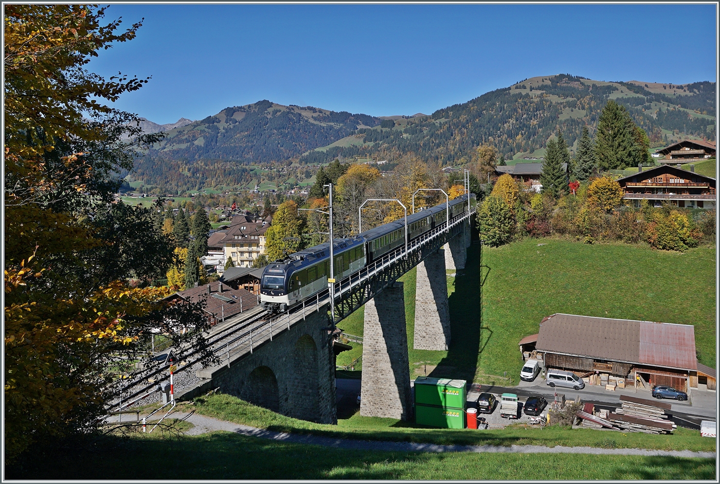 Der MOB ABe 4/4 9303 und ein weiterer sind mit dem PE 30 GoldenPass Belle Epoque 2219 auf der Fahrt von Zweisimmen nach Montreux und überqueren die Grubenbachbrücke in Gstaad. 13. Oktober 2025