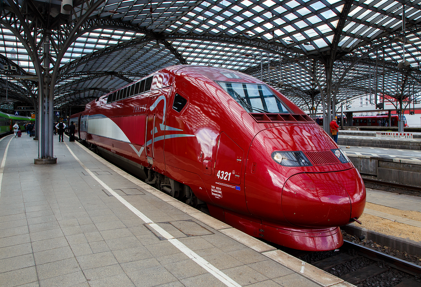 Der PBKA Thalys 4321 - TGV 432710 (93 88 0043 210-7 B-TH etc.) hat, als Thalys 9435 von Paris Gare du Nord (Paris Nord) via Bruxelles-Midi (Br�ssel-S�d), Li�ge-Guillemins (L�ttich) und Aachen Hbf, am 30.04.2023 den Hauptbahnhof K�ln.

Die 17 vorhandenen Thalys PBKA sind zus�tzlich in der Lage, im deutschen Netz mit 15 kV, 16,7 Hz Wechselstrom und einer Leistung von 4.460 kW zu fahren. Das Design ihrer Triebk�pfe lehnt sich an den TGV Duplex an. Sie bedienen seit dem 14. Dezember 1997 K�ln. 

Von den 17 Einheiten (mit je 2 Triebk�pfen und 8 Mittelwagen) befinden sich sieben im Eigentum der NMBS/SNCB, sechs geh�ren der SNCF, je zwei der NS und der Deutschen Bahn. Die beiden PBKA-Einheiten Nr. 4321 und 4322 befinden sich im Eigentum der Deutschen Bahn und werden dort intern, wie alle Thalys-PBKA-Triebz�ge, als „Baureihe 409“ bezeichnet. Sie sind Bestandteil des Fahrzeugparks der Belgischen Staatsbahn. Der hier gezeigte Triebzug 4332 ist Eigentum der NS - Nederlandse Spoorwegen  (Niederl�ndischen Staatsbahn).

TECHNISCHE DATEN des Thalys PBKA:
Baureihe: 43000 (Belgien und Frankreich) / 409 (Deutschland)
Hersteller: Alstom
Baujahre: 1993 - 1997
Spurweite: 1.435 mm
Achsfolge:  Bo'Bo'+2'(2)(2)(2)(2)(2)(2)(2)2'+Bo'Bo'
Anzahl der Achsen / davon angetrieben: 26 / 8
Triebzugl�nge: 200 m
Breite der Mittelwagen: 2.750 mm
Anzahl der Mittelwagen: 8 Mittelwagen
Stromsysteme: 25 kV / 50 Hz AC, 15 kV / 16 2/3 Hz AC, 1,5 kV und 3 kV DC
Technisch zugelassene H�chstgeschwindigkeit:  320 km/h
H�chstgeschwindigkeit im Plandienst: 300 km/h
Antriebsleistung des Zuges: 
8.800 kW (unter 25 kV 50 Hz), 
4.460 kW (unter 15 kV 16 2/3 Hz) und 
3.680 kW (unter 3 kV und 1,5 kV) 
Leergewicht:  416 t
Sitzpl�tze: 377, davon 120 in der 1. und 257 in der 2. Klasse bzw. im Restaurant
