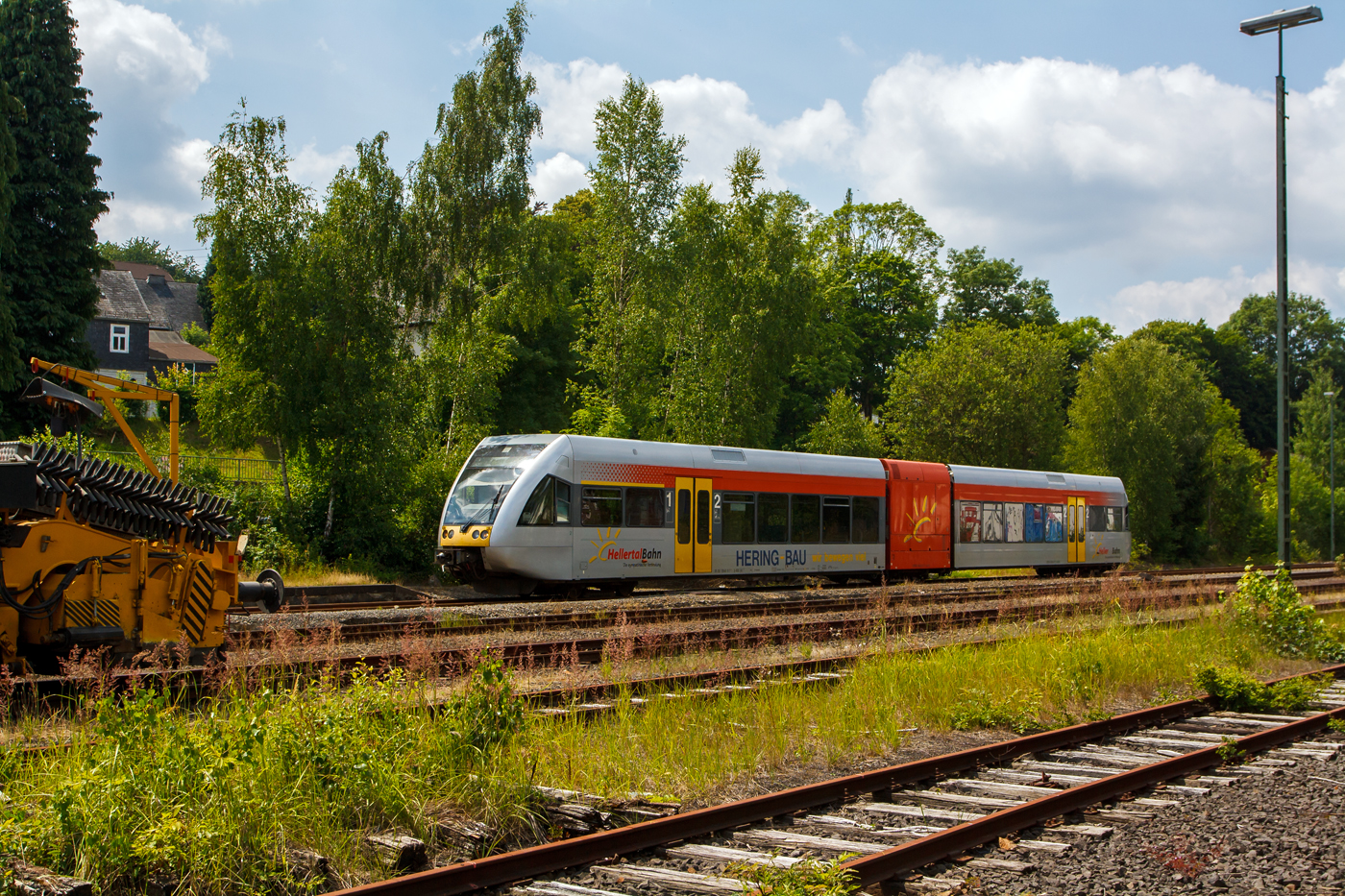 Der Stadler GTW 2/6 - VT 117 (95 80 0946 417-2 + 95 80 0646 417-5 + 95 80 0946 917-1 D-HEB) der Hellertalbahn erreicht am 15 Juli 2013, als RB 96 (Hellertalbahn) Betzdorf/Sieg - Herdorf - Neunkirchen - Haiger – Dillenburg, den Bahnhof Burbach (Kr. Siegen).

Dieser Triebwagen wurde 1999 bei DWA, Bautzen (Deutsche Waggonbau AG, heute Bombardier Transportation) unter der Fabriknummer 525/002 für die Hessische Landesbahn (HLB) gebaut, dessen Eigentum er ist und ihn an die Hellertalbahn vermietet hat. Der elektrische Teil und die Fahrwerke sind von Adtranz (Schweiz). Mit dem Fahrplanwechsel am 14.12.2014 wurden die Linie RB 96 (Hellertalbahn) dann von der Hessische Landesbahn (HLB) übernommen. Somit wurde dann die Hellertalbahn GmbH (mit je 1/3 Beteiligung HLB, KSW und WEBA) Geschichte. Zwei der drei Triebwagen (VT 117 und VT 117) übernahm dann die WEBA (Westerwaldbahn des Kreises Altenkirchen GmbH), für den Einsatz auf der Daadetalbahn RB 97 (Betzdorf – Daaden) übernommen und konnte sie die beiden 628/928 ersetzen. 

Stadler GTW 2/6:
Dieser GTW 2/6 mit dieselelektrischem Antrieb besteht aus: 
Dem mittigem Antriebsmodul (95 80 0646 417-5 D-HEB), auch Antriebscontainer genannt, dessen beiden Achsen angetrieben sind und das Fahrzeug bewegen. Die zwei leicht und niederflurig gebaute Endmodule (95 80 0946 417-1 D-HEB und 95 80 0946 917-2 D-HEB mit je einem Drehgestell stützen sich auf das Antriebsmodul, somit ergibt sich die Achsfolge 2'Bo'2. Es ergibt sich auch eine sehr gute Raumausnutzung der Endmodule, nur ist das Fahrzeug durch das Antriebsmodul in zwei Hälften geteilt und der Gang durch den Antriebscontainer nicht barrierefrei passierbar.

Die Antriebausrüstung besteht aus einem MTU 12V 183 TD 13 V 12 – Zylinder - Dieselmotor der seine 550 kW Leistung auf einen Dreiphasen-Generator überträgt der zwei Asynchronmotoren (Adtranz, 6 RIA 4548) antreibt. Die max. Leistung an den Rädern beträgt 420 kW, die Höchstgeschwindigkeit 120 km/h. Der kompl. Triebwagen hat eine Länge über Kupplung (Scharfenbergkupplung) von 38.660 mm und ein Eigengewicht von 52 t.

Weitere TECHNISCHE DATEN:
Spurweite: 1.435 (Normalspur)
Achsfolge: 2'Bo'2.
Länge über Scharfenbergkupplung: 38.660 mm
Breite: 3.000 mm
Höhe: 3.850 mm
Eigengewicht: 52 t
Achsabstand im Drehgestell: je 2.000 mm
Antriebsmotor: MTU 12V 183 TD 13
Treibraddurchmesser (neu): 860 mm
Laufraddurchmesser (neu): 680 mm
Höchstgeschwindigkeit: 120 km/h
Max. Beschleunigung: 0,88 m/s²
Anfahrzugkraft: 62 kN
Sitzplätze: 120
Stehplätze: 103 (bei 4 Pers./m²)
