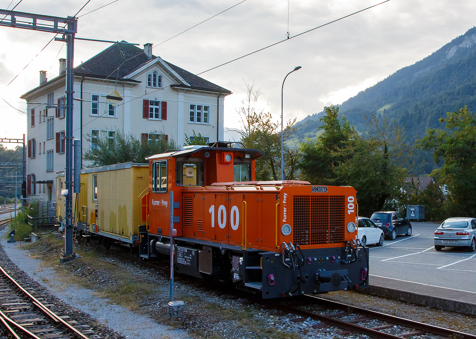 Der Tmf 2/2 100 der Furrer+Frey AG steht am 06.09.2021 beim Bahnhof Reichenau-Tamins (aufgenommen aus dem Zug heraus).

Das Meterspur-Multitalent der Furrer+Frey AG (Bern)...
Kupplungen, Bremssysteme und Zug- und Stossvorrichtungen des neuen Tmf 2/2 mit Funkfernsteuerung erlauben seinen Einsatz auf allen Schweizer Meterspurbahnen.

VIELSEITIG:
Der Sch�ma Tmf 2/2 (100) ist f�r den Einsatz auf Steigungen bis 70 Promille geeignet.
Er ist ausger�stet mit Magnetschienenbremse, Vakuumbremse und sowohl 4 bar als auch 5 bar Druckluftbremsen.
Dank verstellbaren Zug- und Stossvorrichtungen und dem Radprofil C kann er au�er beim Tram auf allen Schweizer Meterspurbahnen eingesetzt werden.
Auf den Einbau einer Zugsicherung wurde f�r dieses Baustellenfahrzeug verzichtet. Die Systeme der Bahnen sind so verschieden, dass sie sich teilweise gegenseitig ausschlie�en.

Die Meterspur-Lok vom Typ SCH�MA CFL 250 BCL-R wurde 2018 von SCH�MA (Christoph Sch�ttler Maschinenfabrik GmbH) in Diepholz unter der Fabriknummer 7007 gebaut, am 07.11.2018 erfolgte die Auslieferung an die Furrer + Frey AG, Bern [CH]  als Tmf 100. Auch wenn sie nur als Tmf 100 gef�hrt wird hat sie die UIC-Nummer 99 85 8290 100-9 CH-FFAG.

TECHNISCHE DATEN:
Baujahr: 2018
Spurweite: 1.000 mm (Meterspur)
Achsfolge: B
L�nge �ber Puffer (abh. V. installierten Kupplungstyp): GFN - 8.870 mm / ZP1 - 8.470 mm / ZP2 - 8.340 mm
Achsabstand: 3.750 mm
Triebraddurchmesser 850 mm.
Achsabstand 3.750 mm.
Breite 2.670 mm
H�he 3.650 mm
Breite: 2 700 mm
Eigengewicht:  28,0 t
H�chstgeschwindigkeit: 65 km/h (75 km/h Schleppfahrt)
Dieselmotor: Wassergek�hlter Caterpillar  6-Zylinder-Reihen-Viertakt-Dieselmotor mit Turboaufladung vom Typ CAT C13 ACERT
Motorleistung: 354 kW (481PS)
Motor Hubraum: 12,5 l (Bohrung 130 mm x Hub 157 mm)
Retarder:  Voith VR 120-3 
Lastschaltgetriebe: DANA 8422H-257, 4 G�nge f�r jede Fahrtrichtung
Bedienung: aus F�hrerstand und/oder Funkfernsteuerung
Steigung / Gef�lle: Zugelassen f�r den Betrieb bis 70 ‰
Bremse: Druckluftbremse (4 oder 5 bar) und Vakuumbremse
Anh�ngelasten: �berf�hrungsbetrieb Bau- und Man�verbetrieb
bis 10 ‰ 130 t bei 40 km/h max. 350 t bei 15 km/h
bis 15 ‰ 95 t bei 40 km/h max. 325 t bei 10 km/h
bis 20 ‰ 70 t bei 40 km/h max. 250 t bei 10 km/h
bis 30 ‰ 40 t bei 40 km/h max. 170 t bei 10 km/h
bis 40 ‰ 35 t bei 40 km/h max. 125 t bei 10 km/h
bis 50 ‰ 22 t bei 30 km/h max. 95 t bei 10 km/h
bis 60 ‰ 18 t bei 30 km/h max. 75 t bei 10 km/h
bis 70 ‰ 10 t bei 30 km/h max. 60 t bei 10 km/h

Bemerkungen: Das Fahrzeug ist mit einem Partikelfilter ausger�stet.
Transport auf LKW-Tiefg�nger, Eigenfahrt oder Verlad auf Bahnwagen.
Auf- und Ablad mit Kran, Anschlagmittel teils vorhanden. 
Ausger�stet mit Radprofil C, welches Eins�tze auf allen Meterspurbahnen in der Schweiz erlaubt.
Es k�nnen alle in der Schweiz vorkommenden Typen von Zug- und Sto�vorrichtungen, mit unterschiedlichen H�hen, montiert werden (GFN, ZP1 und ZP2).
Zulassung: Schweiz: Meterspur (ohne Meterspur Tram)

Quelle: Furrer + Frey AG
