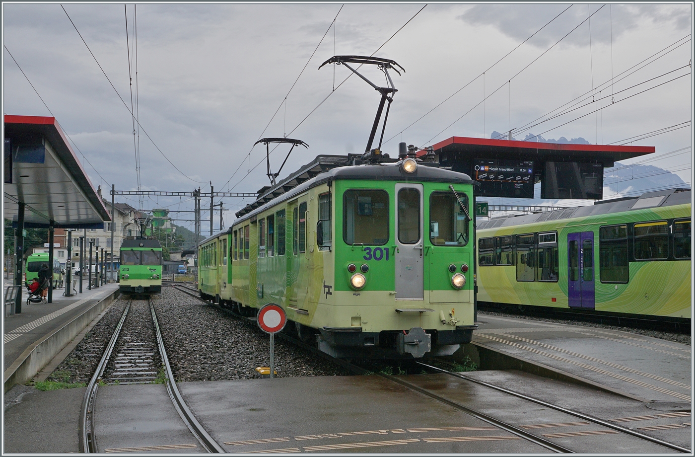 Der TPC A-L BDeh 4/4 301 mit Bt, abfahrbreit nach Leysin und im Hintergrund der ausser Takt angekommene BDeh 4/4 313 mit Bt, der nun im Bahnhof von Aigle abgestellt ist. 

21. Juli 2024