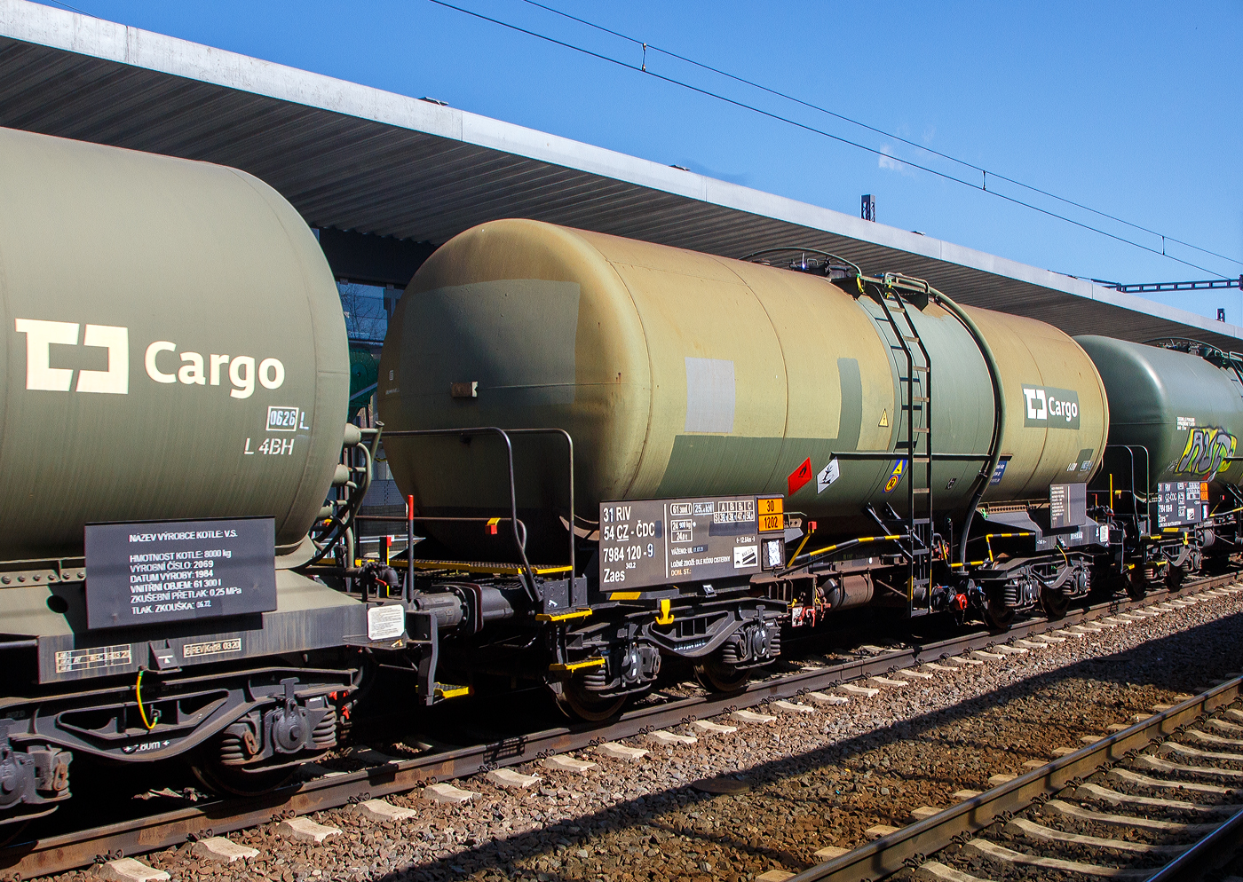 Der vierachsige Drehgestell-Kesselwagen, 31 54 7984 120-9 CZ- ČDC, der Gattung Zaes 343_2 (ČDC Zaes 51 II), der ČD Cargo / České dráhy Cargo (Tschechische Bahnen Cargo), laut Gefahrgutkennzeichnung (30/1202) beladen mit Dieselkraftstoff bzw. leichtem Heizöl, am 19 April 2023 eingereiht in einen Güterzug bei der Durchfahrt im Bahnhof Karlovy Vary (Karlsbad). Auffällig ist das diese Wagen Dampfheizungsröhren besitzen, was man gut an dem vorangestellten Wagen sehen kann, die man hier bei dem Gasöl aber nicht benötigt. 

Die Bedeutung der Gattung Zaes:
Z = Kesselwagen
a = 4 Radsatz
e = mit Heizung
s = zugelassen für Züge bis 100 km/h

TECHNISCHE DATEN:
Gattung: Zaes
Spurweite: 1.435 mm
Anzahl der Achsen:
Länge über Puffer : 12.640 mm
Drehzapfenabstand: 7.600 mm
Achsabstand im Drehgestell: 1.800 mm
Drehgestellbauart: Y 25 Cs oder Y 25 Rs
Höchstgeschwindigkeit: 100 km/h  (ursprünglich leer 120 km/h)
Eigengewicht: 24.900 kg
Nutzlast: 54,0t ab Streckenklasse C
Gesamtvolumen: 61300  Liter
Tankcode: L4BH
Behälterabmessung: Ø 2800 mm x 10.769 mm lang
Behälterwerkstoff : Normalstahl
Kleinster befahrbarer Gleisbogen: R= 150 m
Bremse: DAKO CV1-D16
Intern. Verwendungsfähigkeit: RIV 