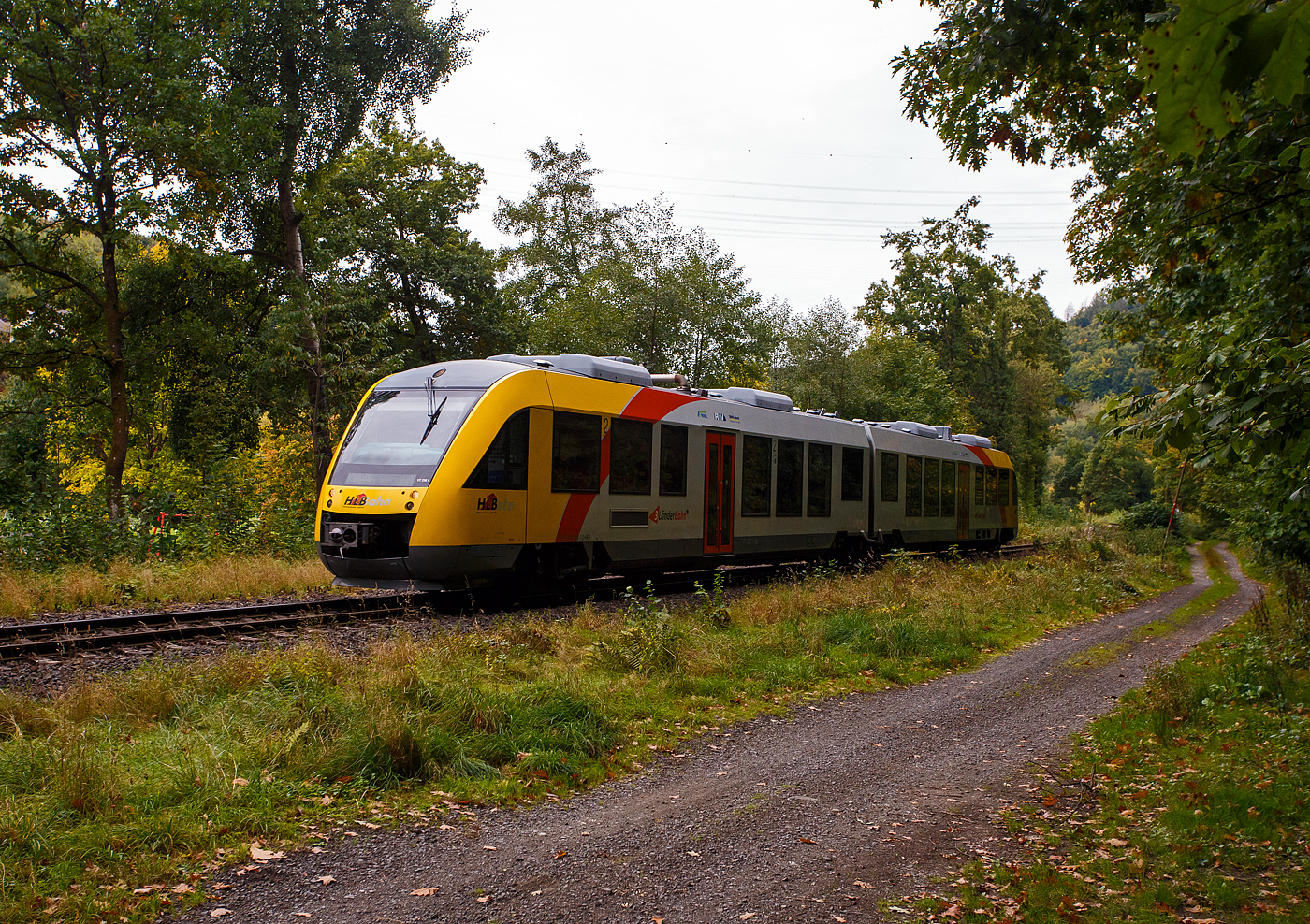 Der VT 258 (95 80 0648 158-3 D-HEB / 95 80 0648 658-2 D-HEB) ein Alstom Coradia LINT 41 der HLB (Hessische Landesbahn) erreicht am 03 Oktober 2025, als RB 96  Hellertalbahn  (Dillenburg – Haiger – Herdorf – Betzdorf/Sieg), bald den Hp Grünebach Ort. So langsam verfärben sich die ersten Blätter, es wird Herbst.

Der Alstom Coradia LINT 41 wurde 2004 von der ALSTOM Transport Deutschland GmbH (vormals LHB - Linke-Hofmann-Busch GmbH) in Salzgitter-Watenstedt unter der Fabriknummer 1188-008 für die vectus Verkehrsgesellschaft mbH gebaut, mit dem Fahrplanwechsel am 14.12.2014 wurden alle Fahrzeuge der vectus nun Eigentum der HLB, die Hessische Landesbahn hatte 74,9% der Gesellschaftsanteile.
