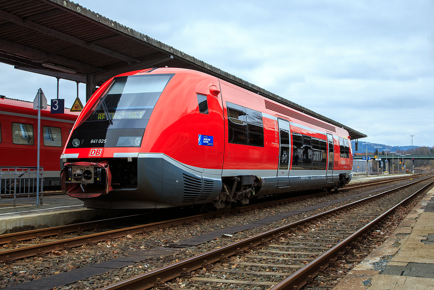 Der VT 641 025 (95 80 0641 025-1 D-DB), ein Alstom Coradia A TER Dieseltriebwagen besser bekannt als „Wal“, der DB Regio, als RE 38 „Main-Saale-Express“ (Lichtenfels – Kulmbach – Hof), am 26.03.2016 beim Halt im Bahnhof Neuenmarkt-Wirsberg.

Der Triebwagen wurde 2001 von ALSTOM Transport Deutschland GmbH (vormals LHB) in Salzgitter-Watenstedt unter der Fabriknummer 25 gebaut.

Diese einteiligen Dieseltriebwagen der BR 641 sind Alstom Coradia A TER Triebwagen. Ihre Entwicklung begann als Gemeinschaftsprojekt der Deutschen Bahn AG und der franz�sischen SNCF mit den Schienenfahrzeugherstellern De Dietrich Ferroviaire und Linke-Hofmann-Busch. Sie wurden arbeitsteilig von diesen heute als Alstom Transport Deutschland und Alstom DDF zum Alstom-Konzern geh�renden Unternehmen hergestellt. TER steht f�r Transport express r�gional.

Einteiliger Triebwagen f�r den Einsatz auf Nebenstrecken in l�ndlichen und d�nn besiedelten Gebieten. Bei dieser Baureihe handelt es sich um einen Leichttriebwagen mit unterflur angeordneter Antriebsanlage. Im Gegensatz zum VT 640 ist die Baureihe 641 mit zwei Antriebsanlagen ausgestattet und auf Grund der guten Motorisierung auch f�r steigungsreiche Strecken vorgesehen.

Der Wagenkasten setzt sich aus der Fahrgastzelle und zwei GFK-Vorbauten zusammen. Dabei fungieren die Vorbauten als „Knautschzone“, sie fangen im Kollisionsfall die Aufprallenergie weitgehend ab. Die zwei Schwenkschiebet�ren je Fahrzeugseite sind nicht doppel- sondern nur einfl�gelig ausgef�hrt. An einen der Einstiegr�ume schlie�t sich ein kleiner Mehrzweckraum an, in den eine behinderten-freundliche Sanit�rzelle integriert ist.

Von diesem Leichttriebwagen befindet sich 40 Fahrzeugen bei der DB AG, mehr als 340 Fahrzeugen (X-TER 73 500) bei der SNCF und 6 Fahrzeugen (S�rie 2100) bei der CFL im Einsatz.
Die spurtstarken Triebwagen mit unterflur angeordneten Antriebsanlagen fahren vor allem im Personenverkehr mit schwachem bis mittlerem Fahrgastaufkommen.

Wegen seinem charakteristischen Aussehen, haben die Triebwagen in Deutschland den Spitznamen „Wal“ und in Frankreich (wo sie meist eine blaue Farbgebung haben) den Spitznamen Baleine bleue (Blauwal) bekommen.

Technische Daten:
Achsfolge: (1A)’(A1)’
Spurweite: 1.435 mm (Normalspur)
Drehgestellabstand: 17.500 mm
Gr��te L�nge �ber Kupplung: 28.888 mm
Gr��te Breite: 3.044 mm
Gr��te H�he: 3.818 mm
H�chstgeschwindigkeit: 120 km/h 
(Die SNCF X 73500 sind in Frankreich f�r 140 km/h zugelassen)
Eigengewicht: 55 t
Sitzpl�tze: 1.Klasse 8; 2.Klasse 55; Klappsitze 17

Motoren:
Anzahl: 2
Art: 6-Zylinder- Viertakt-Common-Rail-Diesel-Motoren (mit Direkteinspritzung)
Typ: MAN D 2866 LUH 21
Leistung: 2 x 257 kW = 514 kW (699 PS)
Anordnung: unterflur, jeweils unter dem F�hrerstand

Getriebe:
Voith-Turbogetriebe, hydraulisch, 2-Gang, Wandler/Kupplung T 211 rze spez. mit Retarder KB 190
Voith-Radsatzgetriebe: mech. SK-445

Scharfenberg Kupplung: Typ 10

Quellen: Oberwei�bacher Berg- und Schwarzatalbahn; Voith
