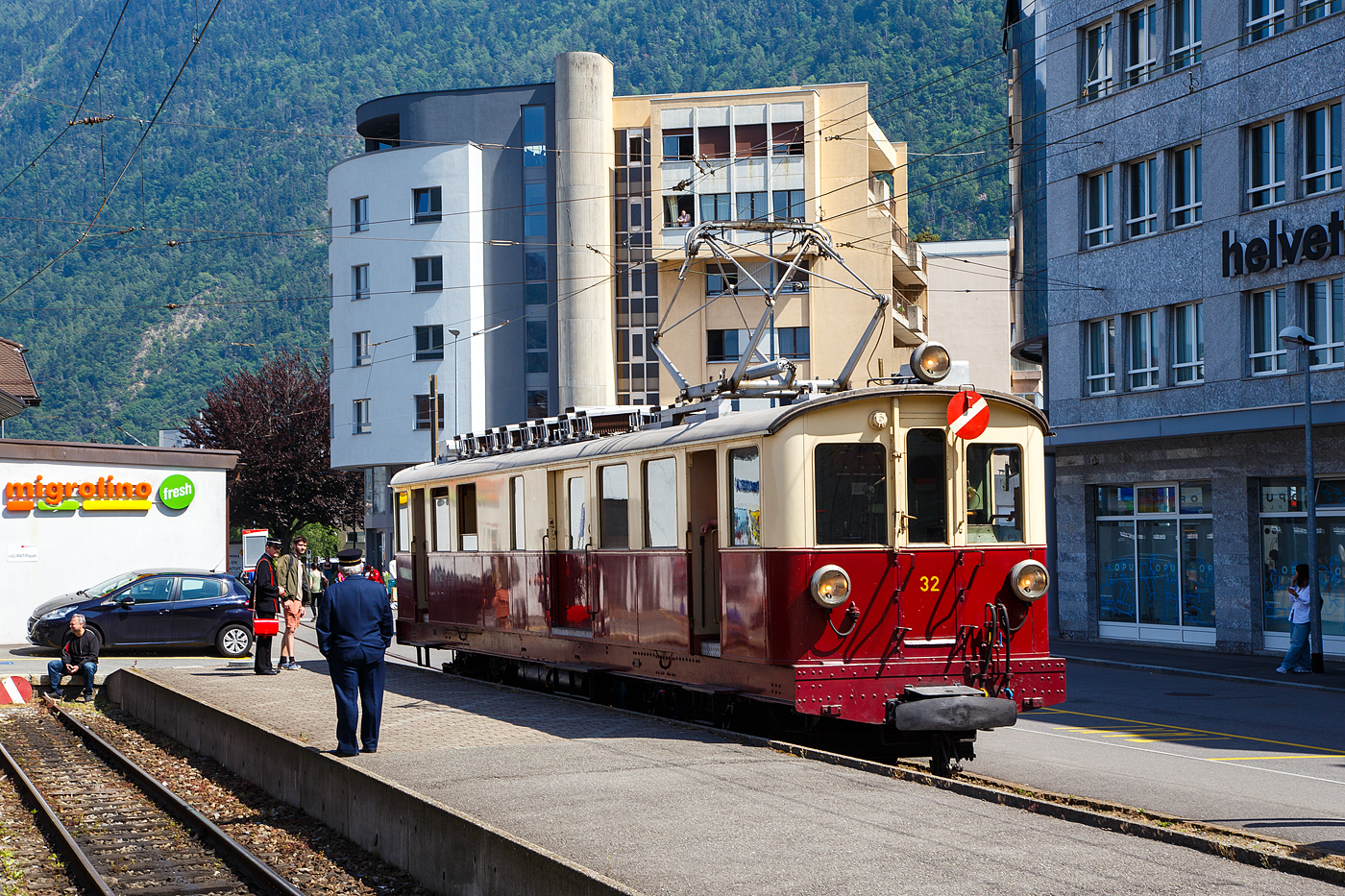 Der wunderschöne ehemalige Martigny-Châtelard-Bahn (MC) Triebwagen ABDeh 4/4 32  le tracteur  ( der Traktor ) vom Verein Train Nostalgique du Trient, ex MC BCFe 4/4, ex SBB CFeh 4/4 N°32 Baujahr 1921, am 26. Mai 2023 im Bahnhof Martigny.

Der Förderverein TNT Train Nostalgique du Trient wurde 1995 wurde 1995 gegründet, dieser bezweckt die alten Fahrzeuge der Schmalspurbahn Martigny-Châtelard-Bahn (MC) im betriebsfähigem Zustand zu halten.

Der meterspurige elektrische Personentriebwagen mit Gepäckabteil für gemischten Zahnrad- und Adhäsionsbetrieb ABDeh 4/4 32 wurde 1921 als CFeh 4/4 für die SBB (für Materialtransporte von der SBB-Station Martigny zum MC-Bahnhof Le Châtelard-Giétroz) gebaut. Während der Arbeiten am Barberine-Staudamm der SBB wurde die Martigny-Châtelard als Transport von Personal und Material ausgewählt. Da die MC (Martigny-Châtelard-Bahn) jedoch nicht über ausreichend Rollmaterial verfügte, bestellt die SBB zwei CFeh 4/4-Triebwagen Nr. 31 und 32. Die Triebwagen mit einer Leistung von 295 kW, waren zum Ziehen von Güterzügen konzipiert (daher auch ihr Spitznamen „der Traktor“), verfügten aber auch über ein großes Frachtabteil sowie ein Fahrgastabteil mit 16 Sitzplätzen in der 3. Klasse. Hersteller der für das Zahnstangensystem Strub konstruierten Triebwagen waren die SWS - Schweizerischen Waggonfabrik Schlieren (mechanischen Teil), die Schweizerischen Lokomotiv- und Maschinenfabrik in Winterthur (Drehgestelle) und die MFO - Maschinenfabrik Oerlikon (elektrische Teil). Neben diesem Triebwagen 32 wurde noch ein weiterer mit der Nr. 31 gebaut, dieser wurde im Herbst 2011 nach Vandalismus und Beschädigung leider abgebrochen. Bis 1926 waren die beiden Triebwagen 31 und 32 Eigentum der SBB (CFF). 

Nach Abschluss der Arbeiten im Jahr 1926 wurden die Triebwagen von der MC übernommen (gekauft) und mit einem zusätzlichen Fahrgastraum der 2. Klasse mit 16 Sitzplätzen ausgestattet und in BCFeh 4/4 umbenannt, nach der Klassenreform dann zu ABDeh 4/4. Seit 1996 ist der Triebwagen beim Verein Train Nostalgique du Trient

Ehemaligebezeichnungen:
SBB / CFF CFeh 4/4 - 32 (bis 1926)
MC CFeh 4/4 – 32 (bis 1935)
MC BCFeh 4/4 – 32 (ab 1935)
MC ABFZeh 4/4 - 32
MC ABDeh 4/4 - 32 (ab 1962)

TECHNISCHE DATEN:
Hersteller: SWS, MFO, SLM
Gebaute Anzahl: 2
Spurweite: 1.000 mm (Meterspur)
Achsfolge: Bozz' Bozz'
Zahnstangensystem: Strub (bzw. Riggenbach)
Länge über Kupplung: 15.940 mm 
Drehzapfenabstand: 7.850 mm 
Breite: 2.700 mm
Höhe: 3.400 mm
Leergewicht: 40,5  t
Dienstgewicht: 43 t
Leistung: 4 x 100 PS = 400 PS (295 kW)
Höchstgeschwindigkeit mit Adhäsionsantrieb: 28 km/h
Höchstgeschwindigkeit mit Zahnradantrieb: 9 km/h 
Antriebsart: Elektrisch über Oberleitung oder seitlicher Stromschiene
Fahrleitungsspannung: 850 V DC (=) (ursprünglich 750 V DC)
Sitzplätze: 32 (je 16 in der 1. und 2. Klasse)
Beschaffungspreis: 49.779.- Franken

Die Martigny-Châtelard-Bahn (Streckennummer 132), abgekürzt MC, (französisch: Chemin de fer Martigny–Châtelard) ist eine 18 km lange meterspurige Bahnstrecke mit Zahnstangenabschnitten (System Strub) mit bis zu 200 ‰ Neigung, in den Adhäsionsabschnitten mit bis zu 70 ‰ Neigung. Die Strecke führt Martigny, Vernayaz MC, Salvan, Les Marécottes, Finhaut und Le Châtelard VS bis zum französischen Bahnhof Vallorcine. In Frankreich verläuft dann die 34 km lange SNCF-Strecke (SNCF KBS 514) von Vallorcine über Chamonix-Mont-Blanc (Anschluss zur Montenvers-Bahn) nach Saint-Gervais-Le Fayet.
