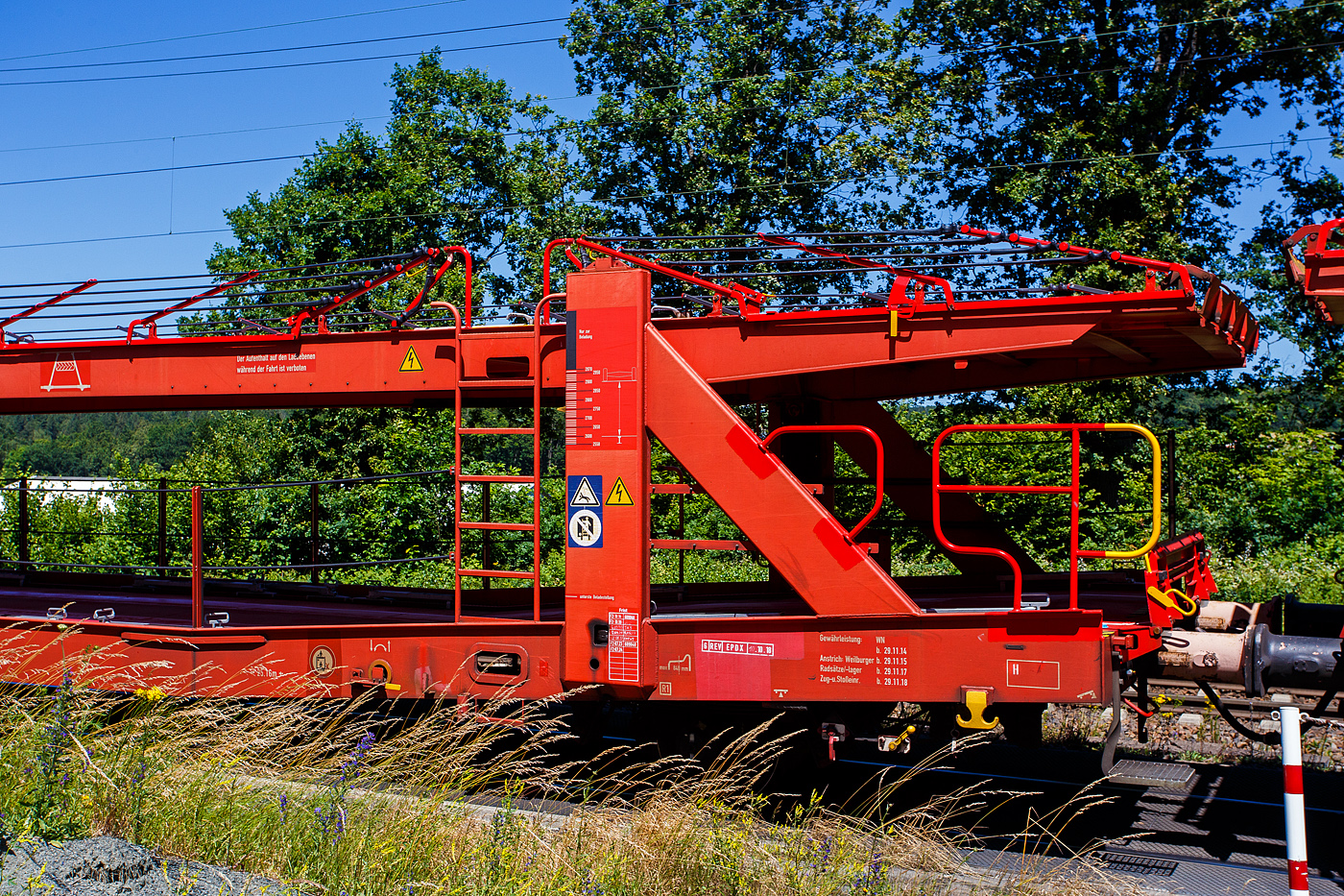Detailbild von dem vierachsigen (2 x zweiachsiger) Doppelstock-Autotransportwagen, 25 80 4371 630-1 D-ATG, der Gattung Laaers 560.1 (BA 5.854) der DB Cargo Logistics GmbH (ex DB Schenker ATG), am 28 Juni 2024 im Zugverband bei der Zugdurchfahrt in Rudersdorf (Kreis Siegen).

Der Wagen wurde 2012 von der damaligen DB Waggonbau Niesky GmbH gebaut.

