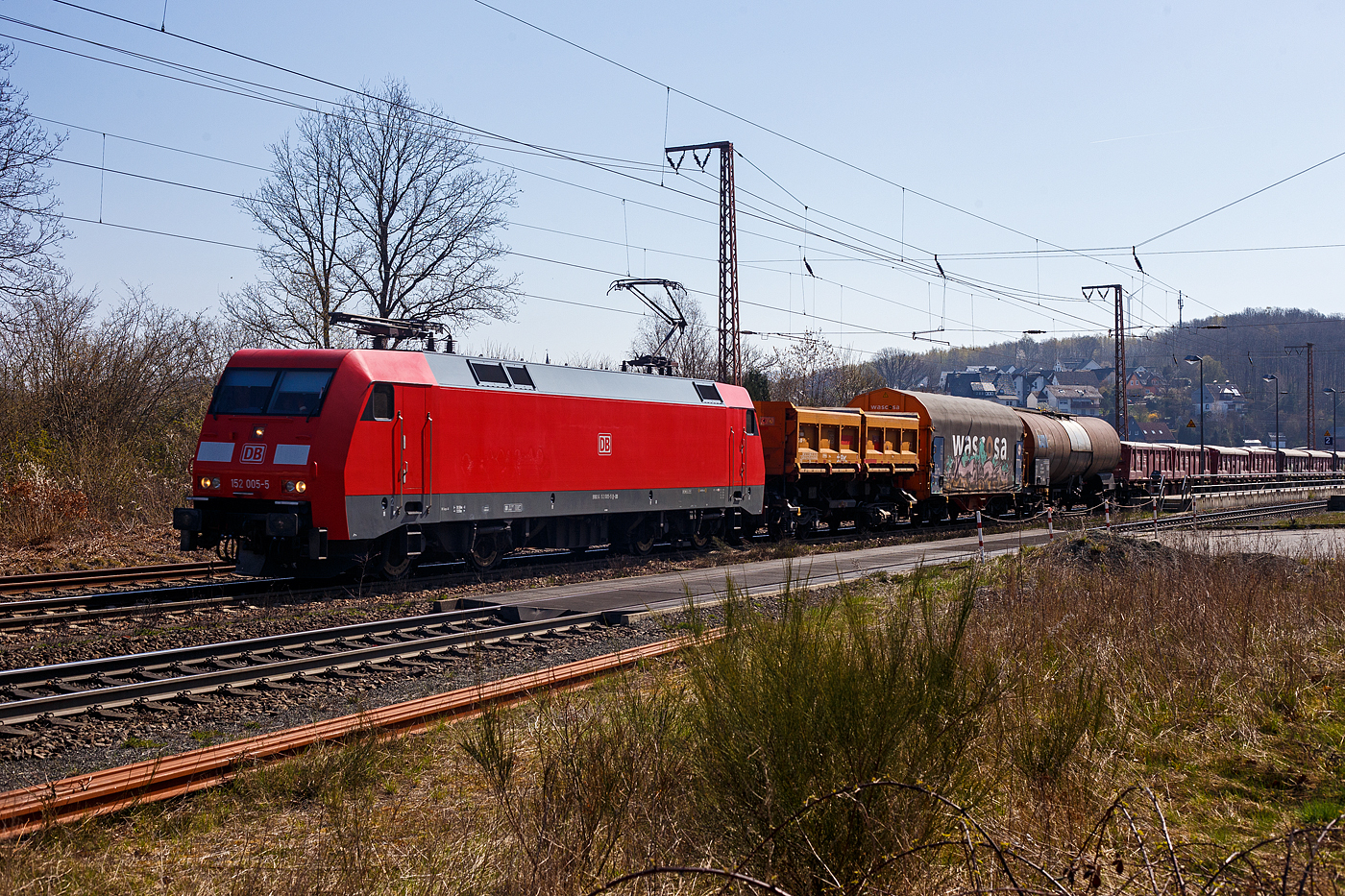 Die 152 005-5 (91 80 6152 005-5 D-DB) der DB Cargo AG fährt am 12 April 2025 mit einem gemischten Güterzug durch Rudersdorf (Kr. Siegen) in Richtung Kreuztal. 

Die Lok wurde 1998 bei Krauss Maffei (heute Siemens) unter der Fabriknummer 20132 gebaut. Von August 2007 bis Januar 2017 fuhr sie mit der Ganzreklame für Landmaschinenhersteller „CLAAS“.
