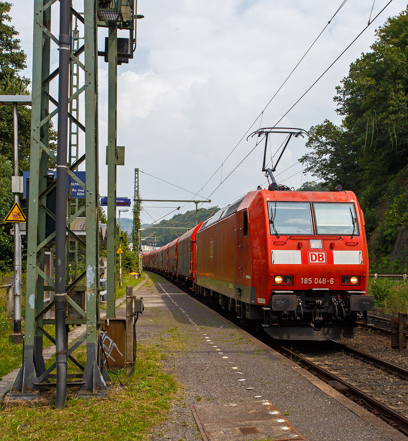 Die 185 048-6 (91 80 6185 048-6 D-DB) der DB Cargo fährt am 03 August  2024 mit einem leeren Coilzug durch Scheuerfeld (Sieg) in Richtung Köln. 

Die TRAXX F140 AC1 wurde 2001 von ABB Daimler-Benz Transportation GmbH, (Adtranz) in Kassel unter der Fabriknummer 33447 gebaut. Sie hat die Zulassungen für Deutschland und Österreich.
