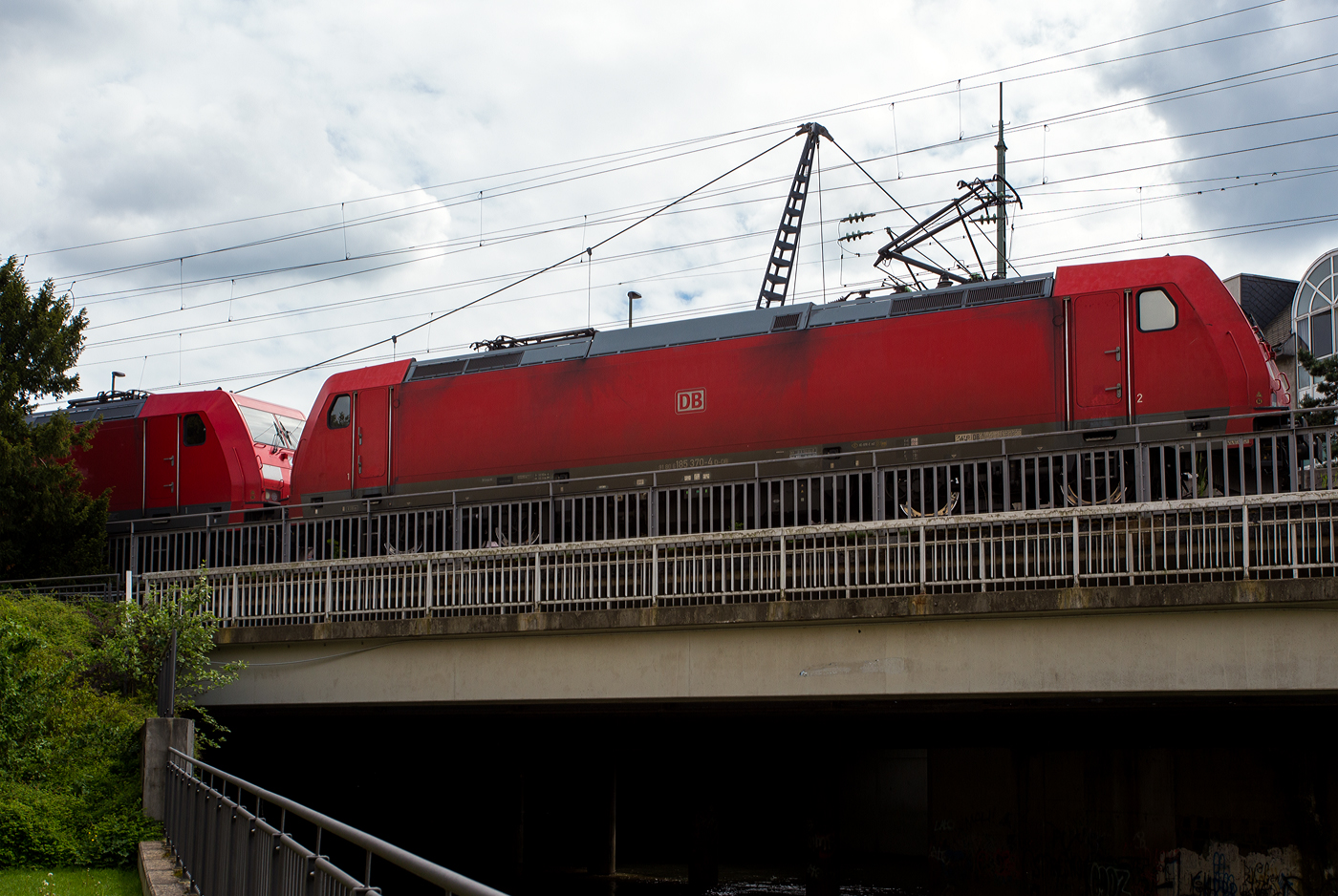 Die 185 370-4 (91 40 6185 370-4 D-DB) der DB Cargo AG fährt am 05 Mai 2024 mit der kalten 185 254-0 (91 40 6185 254-0 D-DB) und einem SUV´s beladenen Autotransportzug der DB Cargo Logistics GmbH, ex ATG, durch Betzdorf (Sieg) in Richtung Köln.