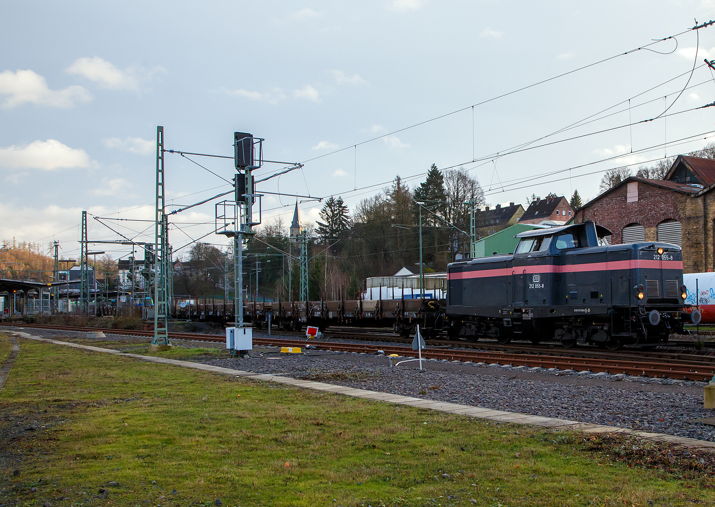 Die 212 055-8 (92 80 1212 055-8 D-JH) der JH - Joseph Hubert Bauunternehmung GmbH & Co. KG (Nürnberg) fährt am 11.01.2023 mit einem Langschienen Zug durch Betzdorf (Sieg) in Richtung Köln. Der Zug bestand aus Drehgestell-Flachwagen, mit Seiten-, Stirnwandklappen und Rungen, der Gattung Res 687, beladen mit Langschienen.

Die V 100.20 wurde 1963 von MaK in Kiel unter der Fabriknummer 1000191gebaut und als DB V 100 2055 an die Deutsche Bundesbahn geliefert. Zum 01.01.1968 erfolgte die Umzeichnung in DB 212 055-8, im Februar 2006 erfolgte die Ausmusterung bei der Railion Deutschland AG (heute wieder DB Cargo) und sie ging nach Ungarn an die LCH - Logistic Center Hungaria Kft. In Győr. Im Jahr 2012 ging sie zurück nach Deutschland an die ALS - ALSTOM Lokomotiven Service GmbH in Stendal, 2015 an Redler-Service und seit 2019 ist sie nun bei der Joseph Hubert Bauunternehmung.
