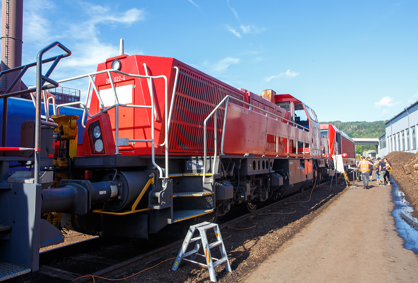 Die 265 022-4 (92 80 1265 022-4 D-DB) eine Voith Gravita 15L BB der DB Cargo AG ausgestellt am 17.09.2023 beim KSW Bahnhof Siegen-Eintracht, hier war im Rahmen der  Europäische Mobilitätswoche  der „Tag der Schiene 2023“ ein Tag der offenen Tür.

Die Die Lok wurde 2013 von Voith in Kiel unter der Fabriknummer L04-18023 gebaut und an die DB Schenker (heute DB Cargo Deutschland AG) geliefert.

Die vierachsigen dieselhydraulischen Lokomotiven vom Typ Gravita 15L BB (BR 265) haben einen Leistung von 1.800 kW und habe somit 800 kW mehr Leistung als eine Gravita 10 BB (BR 261). Zudem sind sie über 1m länger als die kleine Schwester.

TECHNISCHE DATEN:
Spurweite: 1.435 mm
Länge über Puffer: 16.860 mm
Drehzapfenabstand: 8.200 mm
Drehgestell-Mittenabstand: 2.400 mm
größte Breite: 3.075 mm
größte Höhe über SOK: 4.273 mm
Raddurchmesser neu: 1.000 mm
kleinster bef. Gleisbogen: 80 m
Eigengewicht: 84 t
Kraftstoffvorrat: 5.000 l
Motor: V-12-Zylinder-Dieselmotor MTU 12V 4000 R43
Leistung: 1.800 kW bei 1.800 U/min
Getriebe: Voith L 5r4 zseU2
Anfahrzugkraft: 270 kN
Höchstgeschwindigkeit: 100 km/h
Tankvolumen: 5.000 l
Gebaute Stückzahl: 36