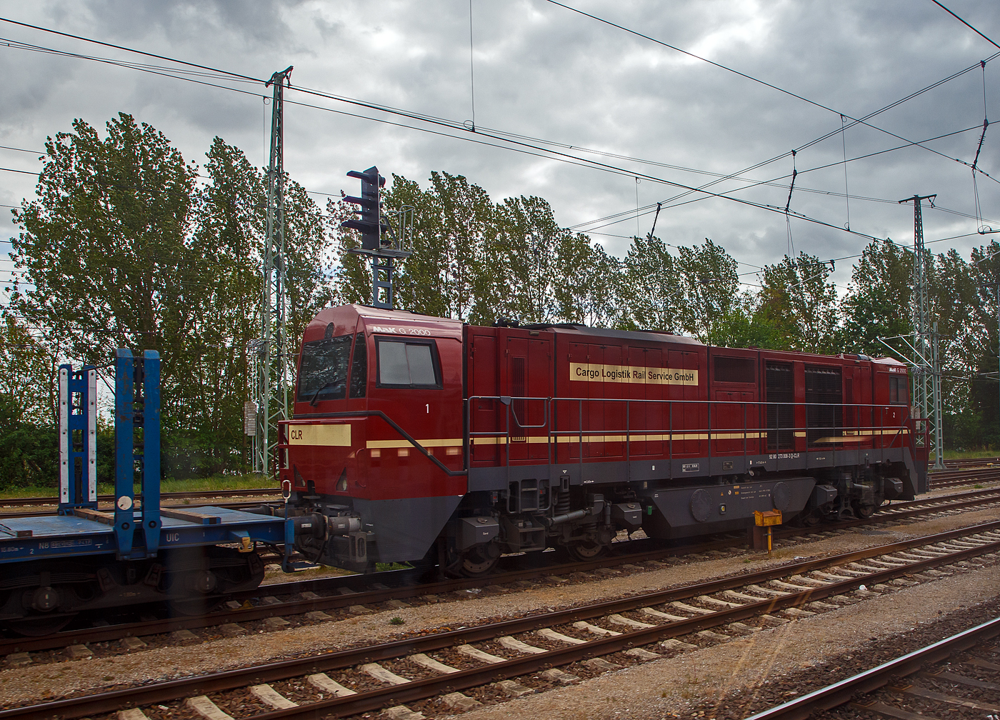 Die 273 008-2 (92 80 1273 008-3 D-CLR), eine Vossloh G 2000 BB, der CLR - Cargo Logistik Rail-Service GmbH (Barleben-Ebendorf) am 14.05.2022 bei Bad Kleinen, aufgenommen aus einem Zug heraus.

Die MaK G 2000 BB in der Variante mit asymmetrischen F�hrerh�usern und mittigen (Ursprungsausf�hrung) und wurde 2001 bei Vossloh in Kiel unter der Fabriknummer 1001036 gebaut und an die RBH - RAG Bahn und Hafen GmbH (Gladbeck) als RBH 904 geliefert, seit 2019 sit sie bei der CLR.

Die Lokomotive Vossloh G 2000 BB ist die st�rkste dieselhydraulische Lokomotive der Vossloh Locomotives GmbH und wird seit dem Jahr 2000 gebaut. Ihre Achsfolge ist B’B’. Sie hat eine Leistung von bis zu 2.700 kW und erreicht je nach Motorisierung eine maximale Geschwindigkeit von bis zu 140 km/h. Je nach Ausr�stungsvariante bringt sie es auf ein Dienstgewicht von 84 t bis 90 t. Dabei erreicht sie eine Anfahrzugkraft von 283 kN bei 87,3 t. Das Tankvolumen betr�gt 5000 l. Insgesamt gibt es 99 Loks der Typen 1–3 und je eine Lok der Typen 4 und 5. 

War das breitere F�hrerhaus zun�chst nur f�r die italienische Ausf�hrung wegen des dort vorgeschriebenen Beimannes und der dort �blichen Linkssteuerung gedacht, wurde es auch bei der dritten Version f�r den Verkehr in Deutschland, Niederlande, Belgien und Frankreich beibehalten, allerdings mit Steuerplatz auf der rechten Seite. Bei der ersten Serie befindet sich der Steuerplatz in der Mitte.

Die Lokomotiven haben einen tragenden Rahmen mit angesetzten Frontschilden als Kollisionsschutz. An beiden Seiten gibt es einen Endf�hrerstand, entweder asymmetrisch, mit einem leicht gewendelten Einstieg (Typ 1) oder (wie hier) �ber die ganze Fahrzeugbreite. Zum Ende ist der F�hrerraum leicht eingezogen, auch ab Fensterunterkante wird er nach oben etwas schmaler. Der Zugang zum F�hrerstand erfolgt von hinten �ber den Umlauf. Der modular aufgebaute Maschinenraum geht nicht �ber die ganze Breite, so dass auf beiden Seiten Platz f�r einen Umlauf mit Gel�nder gibt. Es gibt f�nf Module: Elektronik und Batterien, K�hlanlage mit seitlichen K�hlbl�cken, Verbrennungsluftfilter (�ber dem Getriebe), Motor mit Abgasschalld�mpfer und die Druckluftanlage. Im Bereich der beiden K�hlert�rme sind an der Seite und im Dach gro�e L�ftungsgitter, unterm Dach mit L�ftungsrotoren. Die Lok h�lt das niedrige Umgrenzungsprofil UIC 505-1 ein. Als Drehgestelle werden zweiachsige Flexicoil-Drehgestelle mit Radsatzlenkern verwendet, wie sie auch in den anderen Typen der „vierten Generation“ von Vossloh verwendet werden. Als Motor kommt in der Regel ein Viertakt-Motor Caterpillar 3616 B-HD mit 2.240 kW zum Einsatz. Aufgrund der hohen Leistung ist ein Einbau eines Turbowendegetriebes nicht m�glich, so kommt ein hydraulisches Voith-Getriebe L 620 reU2 mit nachgeschaltetem mechanischen Wendegetriebe zum Einsatz, das nur im Stillstand bet�tigt werden kann.

TECHNISCHE DATEN:
Achsformel: B'B'
Spurweite: 1.435 mm (Normalspur)
L�nge �ber Puffer: 17.400 mm
Drehzapfenabstand: 9.500 mm
Achsstand im Drehgestell: 2.400 mm
Treibraddurchmesser: 	1.000 mm
H�he: 4.220 mm
Breite: 3.080 mm
Dieselmotor: Caterpillar V-16-Viertakt-Dieselmotor mit Turboaufladung und Ladeluftk�hlung vom Typ CAD 3516 B-HD
Motorleistung: 2.240 kW
Motor-Nenndrehzahl: 	1800/min
Getriebe: Voith L 620 reU2
Leistungs�bertragung: hydraulisch
Anfahrzugkraft: 	283 kN
Dienstgewicht: 87,3 t
H�chstgeschwindigkeit: 120 km/h
Kleinster bef. Halbmesser: 80 m
Bremse: KE-GP
Tankinhalt: 5.000 l