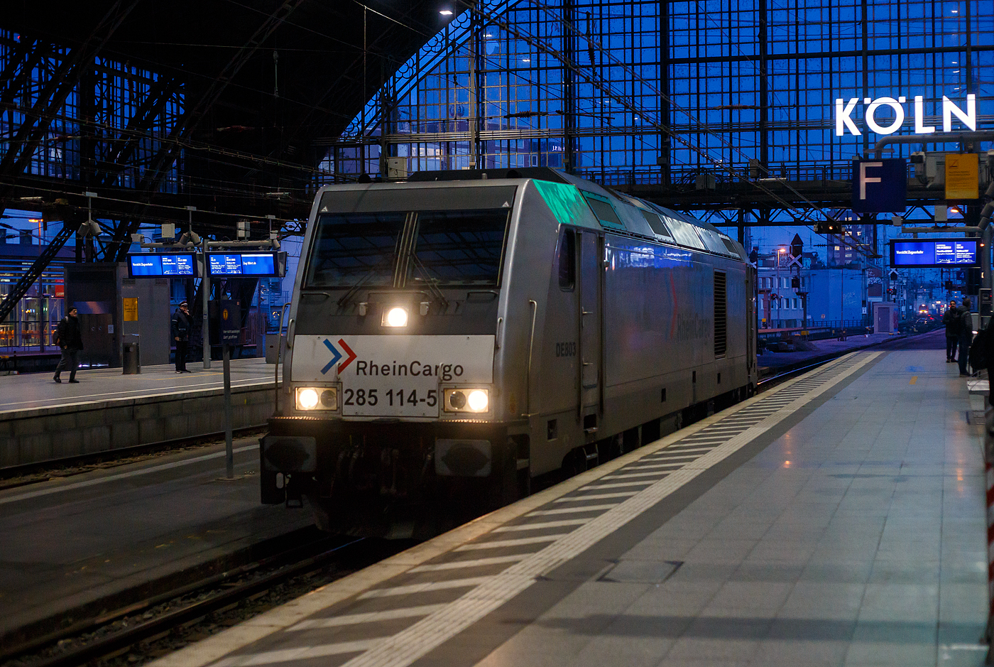 Die 285 114-5/DE 803 (92 80 1285 114-5 D-RHC) der RheinCargo fährt am frühen Morgen des 21 Januar 2025 (8:05 Uhr), auf Tfzf (Triebfahrzeugfahrt) durch den Hauptbahnhof Köln, in Richtung Deutz. 

Die TRAXX F140 DE wurde 2013 von der Bombardier Transportation GmbH in Kassel unter der Fabriknummer 34844 gebaut und als 92 88 00 76 105-0 B-BTK an die BTK Bombardier Transportation GmbH (Kassel) geliefert bzw. eingelagert. Sie war wohl wie vier weitere für einen anderen Kunden vorgesehen. Im Herbst 2013 übernahm der Betreiber RheinCargo aus Neuss die Lieferung der fünf eingelagerten neuen Traxx F140 DE Lokomotiven (76 103-107). Die ersten drei Loks (ex 76 103, 104 und 105) wurden am 01.10.2013 zu den ex HGK-Werkstätten (HGK ist heute Teil der RheinCargo) in Brühl-Vochemon transportiert. Nach einigen Tests und neuen Rheincargo-Logos wurden die drei Maschinen am 21.11.2013 offiziell vorgestellt.

Die Lokomotiven TRAXX F140 DE sind die aus der Plattform Traxx 2e des Herstellers Bombardier hervorgegangene Mehrzweck-Dieselversion. Sie sind mit einem 2.200 kW (3.000 PS) starken MTU 16V 4000 R41L Dieselmotor und elektrischer Wechselstrom-Kraftübertragung ausgestattet, so dass sie eine Anfahrzugkraft von 270 kN und eine maximale Betriebsgeschwindigkeit von 140 km/h erreicht. Diese Lokomotiven sind beliebt bei Unternehmern, die elektrische Traxx-Flotten im Betrieb haben, aber für Strecken mit langen, nicht elektrifizierten Abschnitten zuverlässige Zugkraft brauchen.

TECHNISCHE DATEN der BR 285 (TRAXX F140 DE):
Hersteller: Bombardier Transportation
Baujahre: 2007 bis 2013 (35 Stück)
Spurweite: 1.435 mm
Profil: UIC 505-1
Achsfolge: Bo´Bo´
Länge über Puffer: 18.900 mm
Drehzapfenabstand: 10.440 mm (virtuell)
Achsabstand im Drehgestell: 2.600 mm
Treibraddurchmesser: 1.250 mm (neu) / 1.170 mm (abgenutzt)
Breite: 2.977 mm
Höhe: 4.264 mm
Dienstgewicht: 82 t
Maximale Geschwindigkeit: 140 km/h
Anfahrzugkraft: 270 kN
Dauerzugkraft: 240 kN ab 26 km/h

Dieselmotor Hersteller: Motoren- und Turbinen-Union, Friedrichshafen (MTU)
Dieselmotor Art/Typ: wassergekühlter V-16-Zylinder- 4Takt-Dieselmotor mit zweistufiger Turboaufladung und Ladeluftkühlung, sowie mit Common-Rail-Einspritzsystem vom Typ MTU 16V 4000 R41L
Der Motor schaltet im Leerlauf 8 der 16 Zylinder ab, um den Spritverbrauch und Schadstoffausstoß zu senken.
Motor-Hubraum: 76,265 l (Bohrung 170 mm, Hub 210 mm)
Motorgewicht: 7.930 kg (trocken) / 8.510 kg (nass)
Dieselmotorleistung: 2.200 kW (3.000 PS) bei 1.800 U/min

Kraftübertragung: dieselelektrisch
Traktionsmotoren:  4 Stück Drehstrom-Asynchronmotor
Leistung am Rad: 1.825 kW
Antrieb: Tatzlagerantrieb
Bremskraft: 150 kN
Elektrische Bremsleistung: max. 1.000 kW
Tankvolumen: 5.000 l 
Bauart der Bremsen: Druckluftbremse, Feststellbremse, Dynamische Bremse
Kleister befahrbarer Gleisbogen: R = 100 m
Zugsicherung: GSM-R, PZB90 
Bremsgewicht: P 90 G 77

