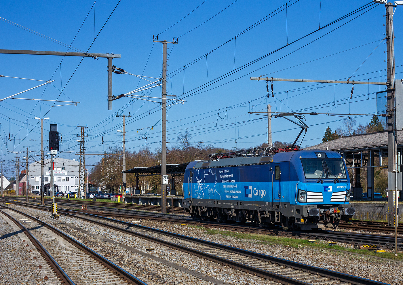 Die 383 003-1 (91 54 7383 003-1 CZ-CDC) der ČD Cargo a.s. (Praha/Prag) fährt am 03. April 2025 auf Tfzf (Triebfahrzeugfahrt) / Lz (Lokzug) durch den Bahnhof Attnang-Puchheim auf den Westbahn in östlicher Richtung (Richtung Wels/Linz). Die Siemens Vectron MS trägt hier Werbung „Quer durch Europa“, was auch kann. 

Die Multisystemlokomotive Siemens Vectron MS wurde 2016 von Siemens Mobilitiy in München-Allach unter der Fabriknummer 22052 gebaut. Sie wurde bei Lieferung in der Variante A01-1d ausgeführt, wurde aber 2020 in die Vectron MS Variante A10 umgebaut. So hat sie aktuell Zulassung für Tschechien, Deutschland, Österreich, Slowakei, Polen, Ungarn, Rumänien und die Niederlande (D / A / SK / PL / CZ / H / RO / NL). So besitzt die Vectron Variante MS A10 folgende Zugsicherungssysteme: ETCS BaseLine 3, sowie für Deutschland (PZB90 / LZB80 (CIR-ELKE I)), für Österreich (ETCS Level 1 mit Euroloop, ETCS Level 2, PZB90 / LZB80), für Polen (SHP), Slowakei und Tschechien (LS (Mirel)), Ungarn (ETCS Level 1, EVM (Mirel)), Rumänien (PZB90) und für die Niederlande (ETCS Level 1, ETCS Level 2, ATB-EGvV).
