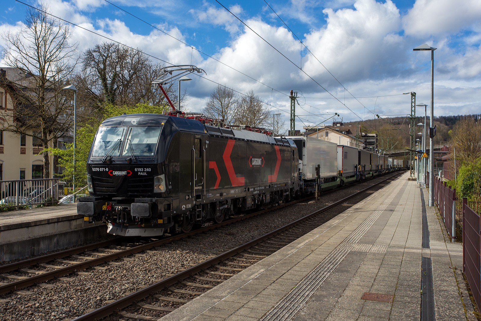 Die an die HELROM GmbH (Frankfurt am Main) vermietete Siemens Vectron MS 5370 071-0   PAUL  / 6193 240 (91 51 5370 071-0 PL-ID) der CARGOUNIT Sp. z o.o. (Wrocław / Breslau) fährt am 28 März 2024 mit dem HELROM Trailer Zug Wien – Düsseldorf, einem besonderen KV-Zug, durch Kirchen (Sieg) in Richtung Köln. Da wegen Schäden auf der folgenden Siegbrücke nur immer ein Zug fahren darf hat sie kurz im Bahnhof hier Hp 0 und muss den entgegenkommenden LINT der HLB abwarten. 

Die Siemens Vectron AC wurde 2023 von Siemens Mobility GmbH in München-Allach unter der Fabriknummer 23519 gebaut und im Januar 2024 an die CARGOUNIT Sp. z o.o. in Wrocław/Polen (Breslau) geliefert. Diese Vectron Lokomotive ist als MS – Lokomotive (Mehrsystemlok) mit 6.400 kW Leistung und 200 km/h Höchstgeschwindigkeit konzipiert. 

In der Version A 10 hat sie die Zulassungen für Polen, Deutschland, Österreich, Niederlande, Slowakei, Rumänien, Ungarn und Bulgarien (PL/D/A/NL/SK/RO/H/BG). Tschechien (CZ) ist z.Z. nach durchgestrichen.

Die CARGOUNIT Sp. z o.o. in Wrocław (Breslau) / Polen wurde 2003 gegründet und stieg 2012 in das Leasinggesellschaft für Lokomotiven ein. Aktuell verfügt Cargounit über einen Fuhrpark von insgesamt 220 Lokomotiven. Das Unternehmen ist der größte Verleiher von Lokomotiven in Polen und die Nummer 5 in Europa. Ende Februar 2024 unterzeichnete CARGOUNIT mit Siemens Mobility einen Vertrag über weitere bis zu 100 Lokomotiven.
