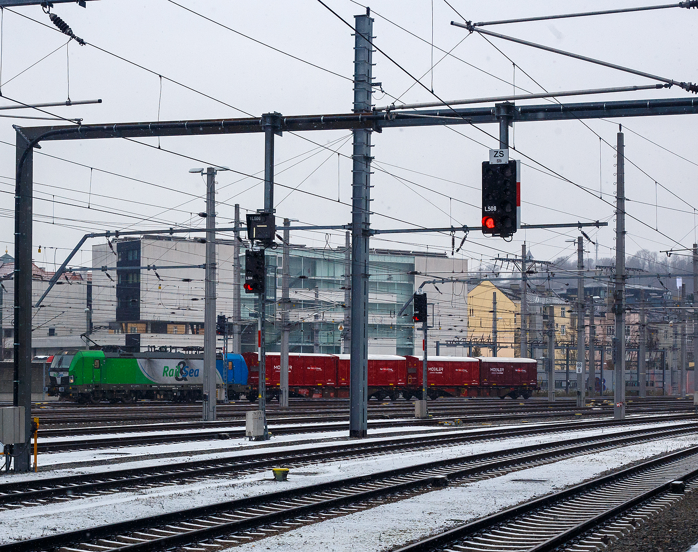 Die an die �BB-Produktion GmbH vermietete SIEMENS Vectron MS 193 273-0 (91 80 6193 273-0 D-ELOC) der ELL - European Locomotive Leasing (Wien) f�hrt am 15 Januar 2025, mit einem kurzen Containerzug (2 Tragwagen beladen mit 4 MOBILER-Container der Rail Cargo Group), durch den Salzburg Hauptbahnhof in �stlicher Richtung. Leider steh ich hier auf dem Bahnsteig 1 und nicht auf 9, so sind einiger Masten dazwischen.

Die Multisystemlokomotive Siemens Vectron MS wurde 2016 von SIEMENS Mobilitiy in M�nchen-Allach unter der Fabriknummer 22034 gebaut. Sie wurde in der Variante MS A17 ausgef�hrt und hat so die Zulassungen f�r Deutschland, �sterreich, Polen, Tschechien, die Slowakei, Ungarn, Rum�nien, Slowenien, Kroatien und Bulgarien (D-A-PL-CZ-SK-H-RO-SL-HR-BG). F�r Serbien (SRB) ist auch eine Zulassung vorgesehen, aber ist z.Z. noch durchgestrichen. Von Januar 2022 bis 2024 war sie an die �sterreichische Rail&Sea Logistics GmbH (Seekirchen am Wallersee) Cargo vermietet, was man an der nicht entfernten Folierung noch erkennen kann.

Die Lok der Variante MS A17 besitzt folgende Zugsicherungssysteme: ETCS BaseLine 3, sowie f�r Deutschland (PZB90 / LZB80 (CIR-ELKE I)), f�r �sterreich (ETCS Level 1 mit Euroloop, ETCS Level 2, PZB90 / LZB80), f�r Polen (SHP, f�r Tschechien und Slowakei (LS (Mirel)), f�r Ungarn (ETCS Level 1, EVM (Mirel)), sowie f�r Rum�nien, Slowenien und Kroatien (PZB90)

