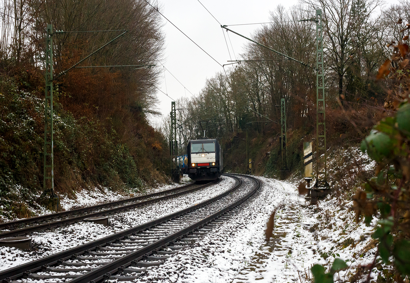Die an die Viking-Rail ApS (mit Sitz im dänischen Padborg) vermietete 185 407-4 (91 80 6185 407-4 D-BRLL) der BRLL - Beacon Rail Leasing GmbH (Grünwald) fährt am 10 Januar 2025 mit einem Tank-Containerzug durch Betzdorf (Sieg) in Richtung Köln.

Die TRAXX F140 AC2 wurde 2011 von der Bombardier Transportation in Kassel unter der Fabriknummer 34961 gebaut und an die MRCE - Mitsui Rai Capital Europe B.V. (91 80 6185 407-4 D-DISPO geliefert. Sie hat die Zulassungen für Schweden, Deutschland und Dänemark. Noch vor der Übernahme der MRCE, wurde die Lok im Dezember 2022 an die Beacon Rail Leasing verkauft.