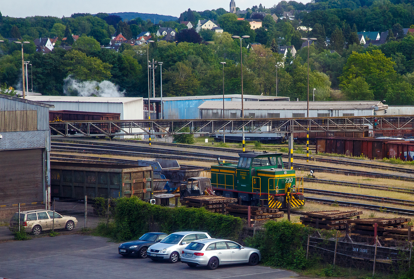 Die DE 730 der Dortmunder Eisenbahn GmbH (98 80 0262 002-5 D-DE), ex Krupp Stahl AG (Werk Bochum) KS-WB 631, eine MaK G 761 C, am 31.05.2022 bei Dortmund. Aufnahme aus dem Zug heraus.

Die dreiachsige Lok wurde 1978 von der Maschinenbau Kiel GmbH (MaK) unter der Fabriknummer 700023 gebaut und an die Krupp Stahl AG geliefert, 1994 �bernahm die DE den Bahnbetrieb im KS Werk Bochum und die Lok ging an die Dortmunder Eisenbahn GmbH, wo sie nun als 730 gef�hrt wird. Zum 01.01.2007 erhielt sie die NVR-Nummer 98 80 0262 002-5 D-DE.

Die Lokomotive MaK G 761 C ist eine dieselhydraulische Lokomotive, die von der Maschinenbau Kiel (MaK) gebaut wurde. Sie war zusammen mit der leistungsst�rkeren G 762 C die erste Bauart des 3. Typenprogramms der MaK, das ab 1977 angeboten wurde. Gemeinsam war diesem Programm, dass nicht mehr auch im Schiffbau verwendete langsam laufenden Motoren aus eigener Produktion, sondern schnelllaufende Fremdmotoren eingebaut wurden, bei diesem Modell von MTU. Auch waren die F�hrerh�user aus Sicherheitsgr�nden nicht mehr direkt vom Boden, sondern nur �ber den Umlauf erreichbar. Die MaK G 761 C hat drei im Rahmen sitzende Achsen, die �ber Gelenkwellen angetrieben werden. Sie ist mit zwei verschiedenen Motoren mit 470 kW bzw. sp�tere 500 kW angeboten worden. Sie erreicht eine maximale Geschwindigkeit von bis zu 55 km/h. Ihre Dienstgewicht betr�gt bis zu 66 t, der Tankinhalt 1.500 l. 

Zwischen 1977 und 1982 wurden 18 Lokomotiven, davon f�nf (wie diese hier) mit dem leistungsschw�cheren Motor, gebaut. Die Lokomotiven wurden �berwiegend an Werk- und Hafenbahnen, vor allem in die Montanindustrie, geliefert. Allein sieben Loks gingen an die Krupp Stahl AG. Je zwei Loks kauften die Shell AG und die Neusser Eisenbahn. Alle 18 gebauten Lokomotiven befinden sich noch im Einsatz. Im Deutschen Fahrzeugeinstellungsregister wurde f�r diese Bauart die Baureihennummer 98 80 0262.0 vergeben.

TECHNISCHE DATEN:
Spurweite:  1.435 mm (Normalspur)
Achsfolge:  C
L�nge �ber Puffer:  9.870 mm
Achsstand: 3.800 mm
gr��te Breite:  3.100 mm
gr��te H�he �ber Schienenoberkante:  4.220 mm
Treibraddurchmesser:  1.000 mm (neu)
kleinster befahrbarer Gleisbogen: 40 m
Dienstgewicht:  54 - 66 t
Kraftstoffvorrat:  1500 l
Motor:  Sechszylinder-MTU-Dieselmotor, Typ  MTU 6V 331 TC11 (sp�tere Vers.TC12)
Leistung: 470 kW  (sp�tere Vers. 500 kW)
Nenndrehzahl: 1.050 U/min
Getriebe: Voith L4r4zU2
Leistungs�bertragung: hydraulisch
H�chstgeschwindigkeit:  30 - 55 km/h
