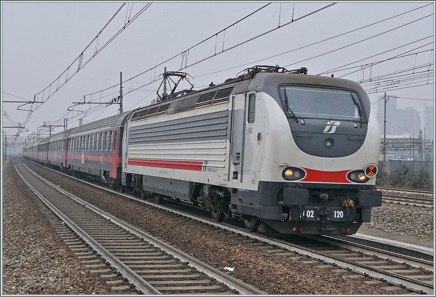 Die FS Trenitala E 402 120 und am Schluss des Zuges die 402 127 sind mit dem Treno di notte ICN 798 von Salerno nach Torino unterwegs. Der Zug erreicht den Bahnhof Rho Fiera Milano wo der ohne Halt durch fährt.

24. Februar 2023