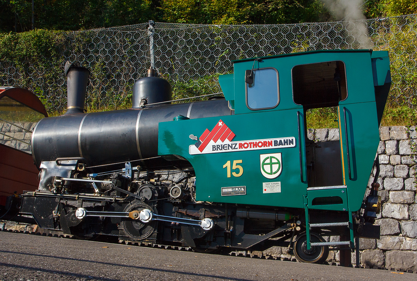 Die Heizöl befeuerte H 2/3 Zahnraddampflok BRB 15 Stadt Kanaya (Japan) am 30.09.2011 im BRB Bahnhof Brienz. 

Die Lok der 3. Generation wurde 1996 bei der Schweizerische Lokomotiv- und Maschinenfabrik, Winterthur (SLM, heute DLM AG) unter der Fabrik-Nr. 5690 gebaut. 

Eine wirklich moderne Dampflokomotive, durch die Befeuerungsart entfällt der zweite Mann, der Heizer, auf der Maschine.

Nachdem die BRB anfing, die vorhandenen Dampfloks durch Dieselloks zu ersetzen, gingen die Fahrgastzahlen zurück, weil Touristikbahnen, wie die BRB, mit dampfgetriebenen Loks beliebter waren. Deshalb bestellte die BRB 1989 zusammen mit der Chemin de fer Montreux–Territet–Glion–Rochers-de-Naye (MTGN) und der ÖBB, welche den Fuhrpark ihrer beiden meterspurigen Zahnradbahnen, der Schafbergbahn und der Schneebergbahn erneuern wollte, bei der Schweizerischen Lokomotiv- und Maschinenfabrik (SLM) drei ölgefeuerte Neubau-Dampfloks. 1992 wurden die drei Loks unter den Fabriknummern 5424 (ÖBB 999.201), 5456 (BRB 12) und 5457 (MTGN 1) geliefert. Aufgrund der Erfahrungen mit den Loks bestellte die ÖBB weitere drei Loks und die BRB zwei Stück. Diese wurden 1995/96 unter den Fabriknummer 5686–5690 (ÖBB 999.202–204, BRB 14–15) geliefert. Da die MTGN-Lok nur für vereinzelte Dampffahrten verwendet wurde, wurde sie schliesslich 2005 an die BRB verkauft, wo sie die Nummer 16 erhielt. Die Nummer 13 wird bei der BRB nicht besetzt.

Technische Daten: 
Spurweite: 800 mm
Zahnstange System: Abt
Leistung: 300 kW (408  PS) 
Zugkraft: 70 kN 
Leergewicht: 13.200 kg
Dienstgewicht: 15.700kg 
Länge über Puffer: 6.260 mm
Breite: 2.200 mm
Höhe: 3.200 mm
Achsfolge: 2zz1' (d.h. 2 nicht angetriebene Tragachsen, 2 Triebzahnräder, 1 bewegliche Laufachse)
Zahnradübersetzung:  1 : 2.3 
Heizölvorrat im Tank: 560 Liter
Wasser im Kessel: 1.200 l
Wasservorrat im Kasten: 1.400l
Verbrauch pro Fahrt Brienz-Rothorn und retour:
Heizölbedarf: 150 l
Wasserbedarf: 2.000 l
Höchstgeschwindigkeit bei 250 ‰: 12 km/h
max. Vorstelllast  bei 250 ‰: 17.000 kg 
max. Kesselüberdruck: 16 bar
max. Überhitzung: 420° C

Keine Feuerung bei Talfahrt: ergeben gute Durchschnittswerte für Abgase. Bei Talfahrt wird die Dampfmaschine als Luftpumpe betrieben, sie bremst den gesamten Zug, zur Kühlung muss Wasser eingespritzt werden.
Gegendruckbremse System Riggenbach
Druckluftbetätigte Federspeicherbremse
Handspindelbetätigte Bandbremse
Elektronische Sicherheits- und Notbremssteuerung
Rückrollsicherung
    
Beschaffungskosten (1996): 2.100.000,00 CHF