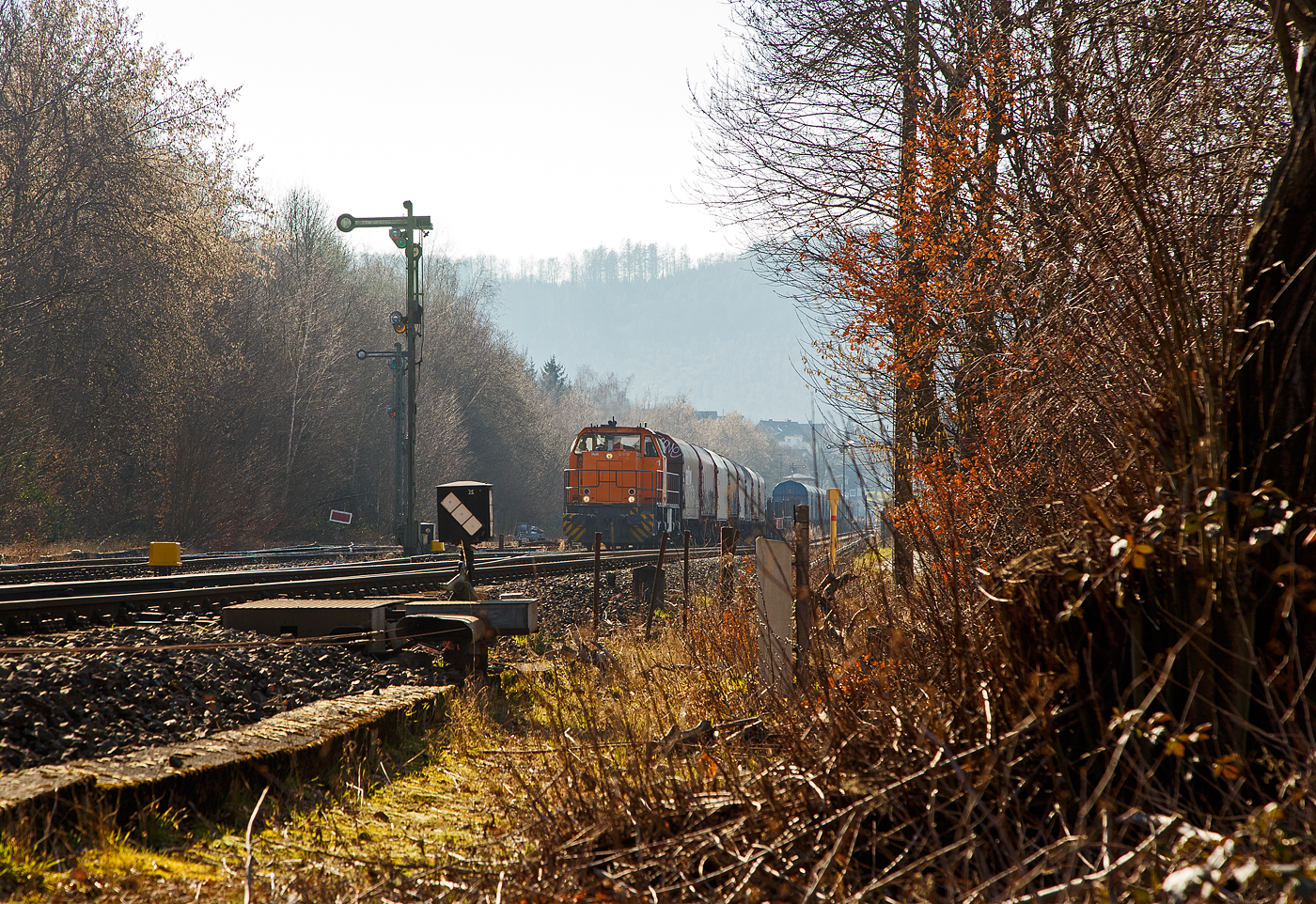 Die KSW 42 (92 80 1277 902-3 D-KSW), eine Vossloh MaK G 1700 BB, drückt am 03.03.2023, weitere leere Güterwagen vom Rangierbahnhof der KSW in Herdorf (Freien Grunder Eisenbahn KSW NE447 / DB-Nr. 9275), in den Bahnhof Herdorf. Im Bahnhof steht bereit die KSW 46 (277 807-4) mit dem ersten Teil von dem Übergabe-Güterzug. Beide Zugteile werden dort dann aneinander gekuppelt und im Sandwich (Vorne die KSW 42 und am Zugschluss die KSW 46), fahren sie dann nach Dillenburg. 

Eigentlich würde sie einfach via Betzdorf nach Kreuztal fahren, aber der Abschnitt Herdorf – Betzdorf bleibt, nach dem Felssturz am 23.12.2022 in Herdorf, bis voraussichtlich zum kleinen Fahrplanwechsel am 09. Juni 2023 gesperrt.