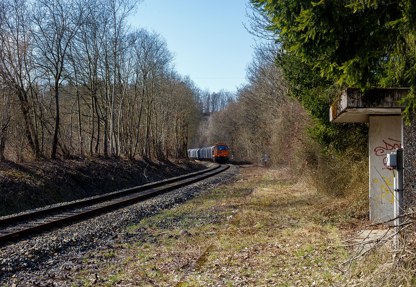 Die KSW 43 (92 80 1273 018-2 D-KSW), die asymmetrische Vossloh G 2000 BB der KSW (Kreisbahn Siegen-Wittgenstein) fährt am 10 März 2025, mit einem beladen Coilzug (VTG Coilwagen der Gattung Shimmns-ttu, VTG Bez. F46.520D) vom Hafen Duisburg kommend über die KBS 462 „Hellertalbahn“ durch Alsdorf in Richtung Herdorf, hier beim Haltepunkt (Hp). 

Bis 1987 war der Abschnitt Betzdorf–Herdorf noch zweigleisig, so war hier an meinem Standort, bis dahin der Bahnsteig für die Fahrtrichtung der Züge nach Betzdorf.