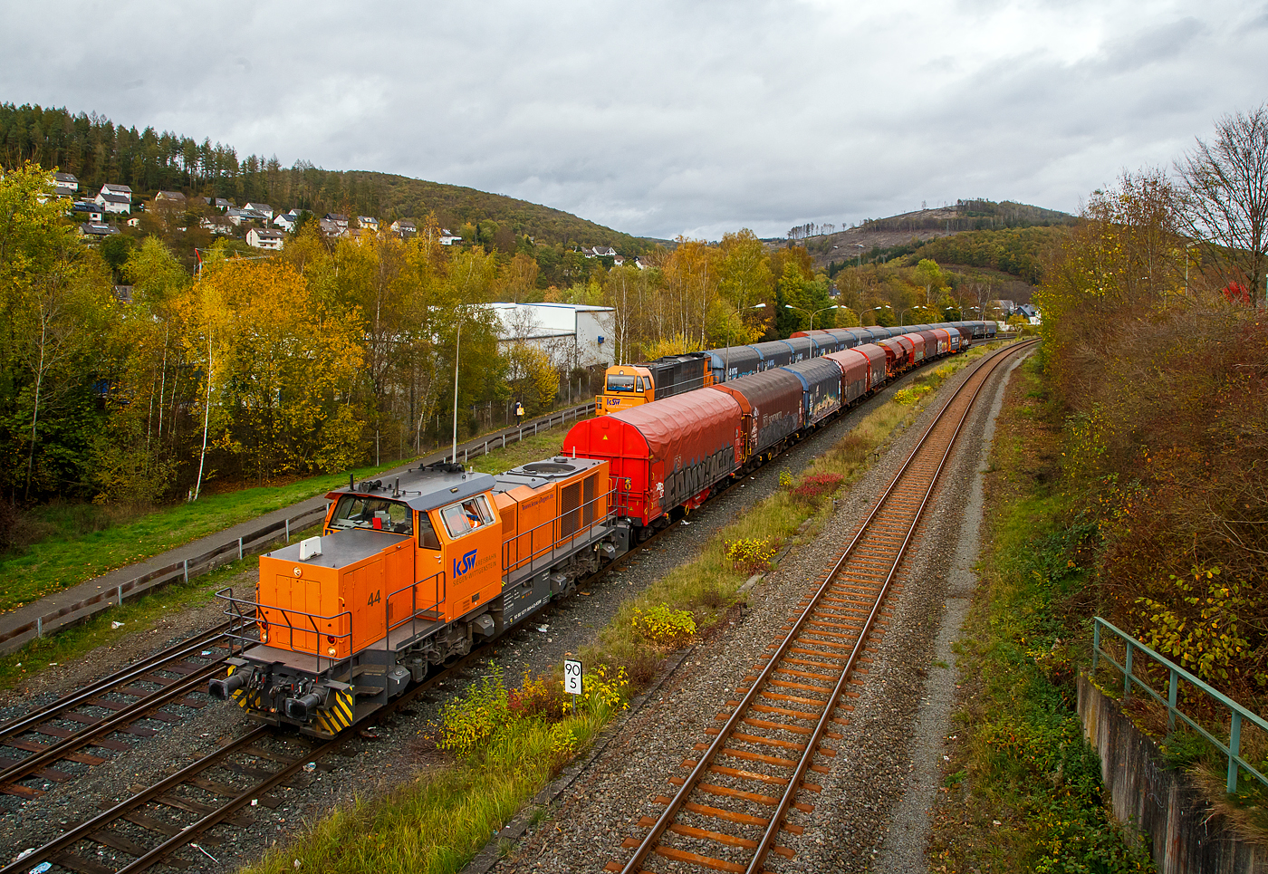 Die KSW 44 (92 80 1271 004-4 D-KSW) eine MaK G 1000 BB der KSW (Kreisbahn Siegen-Wittgenstein), eine MaK G 1000 BB, drückt ihren Güterzug, auf dem KSW Rangierbahnhof Herdorf (Freien Grunder Eisenbahn KSW NE447 / DB-Nr. 9275), an weitere Wagen heran.

Hinten an dem Gleis steht die KSW 43 (92 80 1273 018-2 D-KSW), die asymmetrische Vossloh G 2000 BB der KSW mit einem Übergabezug (leere VTG Coilwagen der Gattung Shimmns-ttu).
