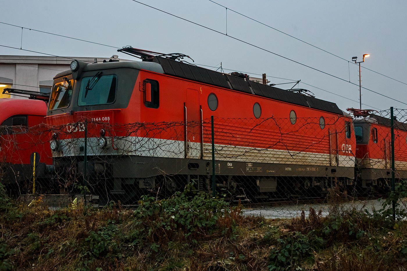 Die ÖBB 1144 085 (A-ÖBB 91 81 1144 085-8), ex ÖBB 1044 085-7 bzw. ex ÖBB 1044.85 steht 15 Januar 2025 (um 7:50 Uhr) beim Lokschuppen/BW beim Hauptbahnhof Salzburg, dahinter die ÖBB 1144 210.  

Die Universallok (ex ÖBB Reihe 1044) wurde 1983 von der Simmering-Graz-Pauker AG in Graz unter der Fabriknummer 76379 gebaut, die elektrische Ausrüstung ist von der ELIN-UNION AG. Sie wurde als 1044.85 an die die ÖBB (Österreichische Bundesbahnen) geliefert, ab dem 01.04.1985 wurde sie als ÖBB 1044 085-7 bezeichnet. Im Jahr 2006 erfolgte dann der Umbau (Einbau einer Wendezugsteuerung) und die Umzeichnung in die heutige ÖBB 1144 085-8.
