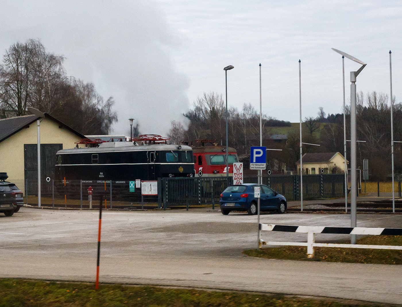 Die �GEG 1010 015-4 in Imperator Majestic Schwarz (A-�GEG 93 81 1010 010-5), ex �BB 1010.15, der �GEG - �sterreichische Gesellschaft f�r Eisenbahngeschichte GmbH ist am 14 Januar 2025 in Timelkam bei der Timelkam Energie AG abgestellt. Bild leider nur aus einem Zug, h�tten wir gewusst was hier alles herumsteht, dann h�tten wir einen Stopp eingelegt.

Die Schnellzuglokomotive wurde 1956 von SGP in Graz (Simmering-Graz-Pauker AG) unter der Fabriknummer 56348 gebaut, die elektrische Ausr�stung ist von BBC - Brown, Boveri & Cie. (andere erhielten die Elektrik von SWS oder Elin). Als �BB 1010.15 wurde sie an die �sterreichische Bundesbahnen geliefert. 1986 f�hrten auch die �BB EDV-gerechte Triebfahrzeugnummern ein. Aufgrund des zukunftssicheren Bezeichnungssystems waren die �nderungen �berschaubar. Die Ordnungsnummern wurden mit einer vorgesetzten Null dreistellig, der Punkt zwischen Stamm- und Ordnungsnummer entfiel und die Selbstkontrollziffern wurden erg�nzt, so wurde aus dieser die �BB 1010 015-4.

Die Reihe 1010 der �sterreichischen Bundesbahnen (�BB) waren sechsachsige elektrische Schnellzuglokomotiven die von 1955 bis 2003 bie der �BB im Einsatz waren. Die Maschinen wurden von Simmering-Graz-Pauker gebaut. Sie waren jahrzehntelang eine wichtige St�tze des elektrischen Bahnbetriebes der �BB.

Im Jahr 2000 verf�gten die �BB noch �ber 18 Lokomotiven. Die Lokomotiven waren zuletzt in Salzburg und Linz beheimatet. Im Jahre 2003 wurden die letzten Lokomotiven zeitgleich mit denen der Reihen 1110 und 1110.500 im Rahmen des Modernisierungsprogramms der �BB ausgemustert. Die letzten Exemplare 1010 003 und 010 schieden am 1. Dezember 2003 aus dem Plandienst aus, sie befinden sich aber bis heute ohne Unterbrechung betriebsf�hig im Nostalgiedienst beim Verein „Club 1018“. Von den 20 gebauten Exemplaren sind neun Lokomotiven erhalten geblieben, alleine vier sind bei der �GEG. 

Mechanische Konstruktion:
Die Lokomotiven erhielten zwei unterschiedliche Drehgestellbauarten. Die 1010.001 und 002 erhielten Drehgestelle ohne Drehzapfen. Aufgrund der Anordnung des mittleren Radsatzes war eine Ausstattung mit herk�mmlichen Drehzapfen nicht m�glich, so dass die beiden Maschinen gemeinsam mit der 1110.05 ein so genanntes aufgel�stes Wiegensystem erhielten. Alle anderen Maschinen der Reihe 1010 erhielten Drehgestelle mit einem tiefliegenden realen Drehzapfen. Bei beiden Varianten waren die Drehgestelle, die den Hauptrahmen und den Lokkasten trugen, quergekuppelt. Die Lokomotiven wiesen abgerundete Stirnseiten auf; die beiden F�hrerst�nde waren miteinander verbunden. Der Trafo befand sich in der Lokmitte, die L�fter, Hilfsapparaturen und Hilfsger�te waren auf Podesten angebracht.

Elektrische Konstruktion:
Alle Lokomotiven hatten zwei Scherenstromabnehmer (Bauart V der Siemens-Schuckert-Werke f�r Einb�gelbetrieb) auf dem Dach. Als Hauptschalter kam erstmals bei den �BB der Druckluftschnellschalter DBTF von BBC zur Anwendung. Bei eingeschaltetem Hauptschalter gelangt die Prim�rspannung �ber den mit dem Prim�rstromwandler ausger�steten Dachdurchf�hrungsisolator zum Haupttransformator. Der Transformator war auf dem Rahmen befestigt und wurde durch ein �lk�hlsystem gek�hlt. Bei den Lokomotiven der Reihen 1010 und 1110 kam erstmals in �sterreich eine Hochspannungssteuerung anstelle der bisher verwendeten Niederspannungsschaltungen zur Anwendung. Die Lokomotiven der Reihen 1010 und 1110 haben sechs solche kompensierten Einphasenreihenschlussmotoren mit offenen Fahnen. Der Anker l�uft auf der Kommutatorseite in einem Pendelrollenlager, das auch den axialen Schub aufzunehmen hat, sowie einem Zylinderrollenlager auf der anderen Motorseite. Diese zehnpoligen, als EM 655 bezeichneten Fahrmotoren wurden aus den bei den Reihen 1040 und 1041 verwendeten, ebenfalls zehnpoligen Motoren EM 601 weiterentwickelt. Die Kraft�bertragung erfolgte mit einem BBC-Federantrieb. Die Getrieber�der waren schr�gverzahnt, die �bersetzung betrug 1:3,18. Alle Lokomotiven waren mit einer schnellwirkenden, automatischen Druckluftbremse, einem Nachbremsventil, einer Zugbremse und einer Schleuderbremse ausgestattet.
	
TECHNISCHE DATEN:
Gebaute Anzahl: 20
Hersteller SGP Simmering-Graz-Pauker AG in Graz (elektr. Teil BBC)
Baujahre: 1955 bis 1958
Spurweite: 1.435 mm (Normalspur)
Achsfolge: 	Co'Co'
L�nge �ber Puffer: 17.860 mm
Drehzapfenabstand: 8.600 mm
Achsstand im Drehgestell: 4.100 mm (2 x 2.050 mm)
Treibraddurchmesser: 1.300 mm (neu)
Dienstgewicht: 109,8t (106,0t bei 01 und 02)
H�chstgeschwindigkeit: 130 km/h
Stundenleistung: 4.000 kW
Maximaler Anfahrstrom: 2.300 A
Anfahrzugkraft: 275 kN
Stundenzugkraft: 158 kN
Dauerzugkraft: 132 kN
Fahrmotoren: 6 St�ck vom Typ EM 665
Fahrmotorart: 10-polige fremdbel�ftete Fahrmotoren mit je 665 kW Stundenleistung 
Antrieb: einseitiger BBC (Brown-Boveri) Federantrieb
Fahrstufen: Hochspannungsstufenschaltwerk Bauart BBC mit 28 Fahrstufen
�bersetzung: 1:3,18
Stromsystem: 15 kV, 16,7 Hz