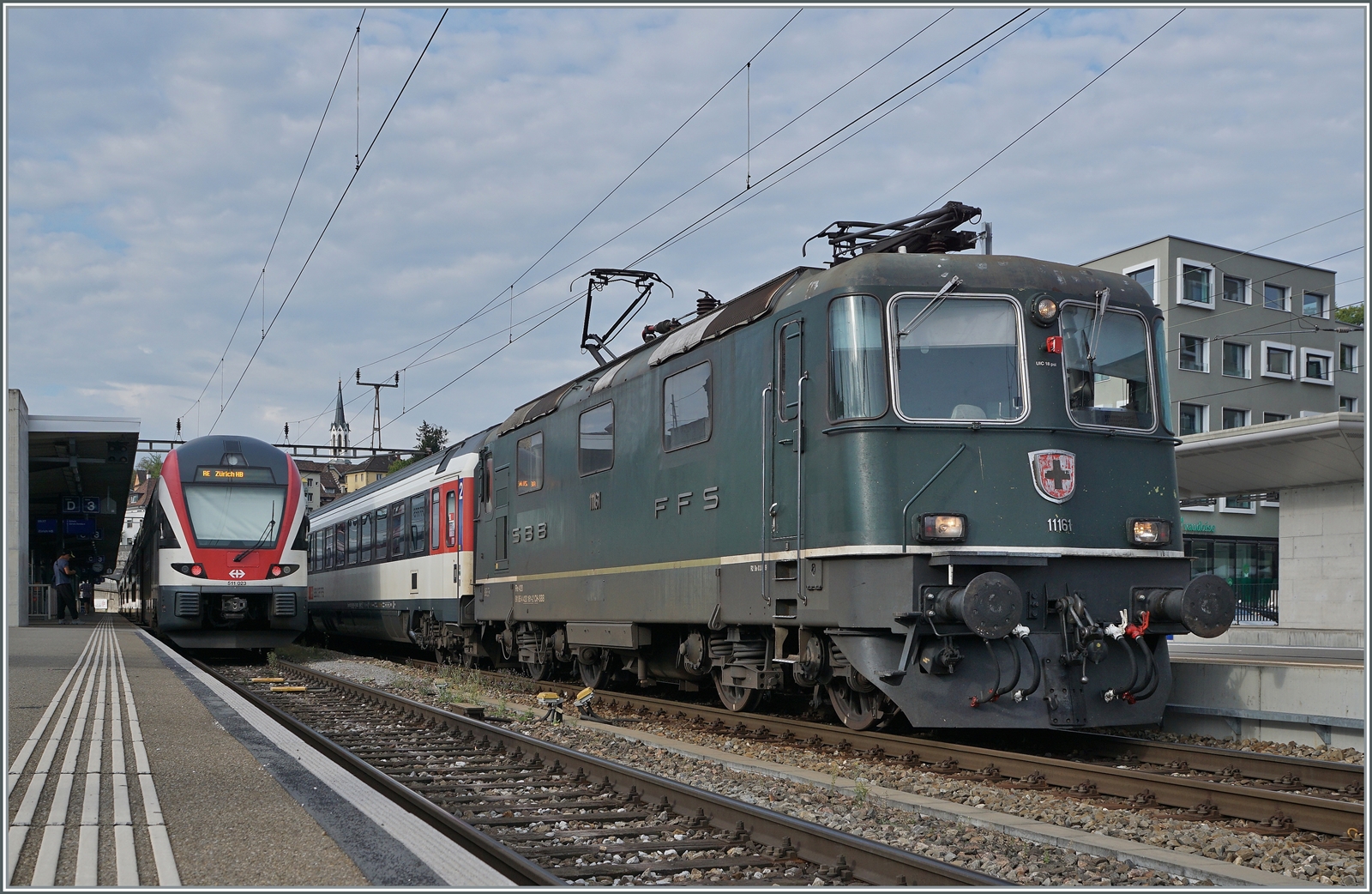 Die SBB Re 4/4 II 11161 in ihrer grünen Lackierung mit einem IC Zürich - Singen wartet in Schaffhausen auf die Abfahrt. Die grüne Farbe ist übrigens NICHT die Ursprungs-Lackierung der Re 4/4 II 11161, die Lok wurde 1967 in TEE Farben ausgeliefert und bekam erst nach dem Ende des TEE-Einsatzes 1981/82 die heutige grüne Lackierung. 

6. September 2022