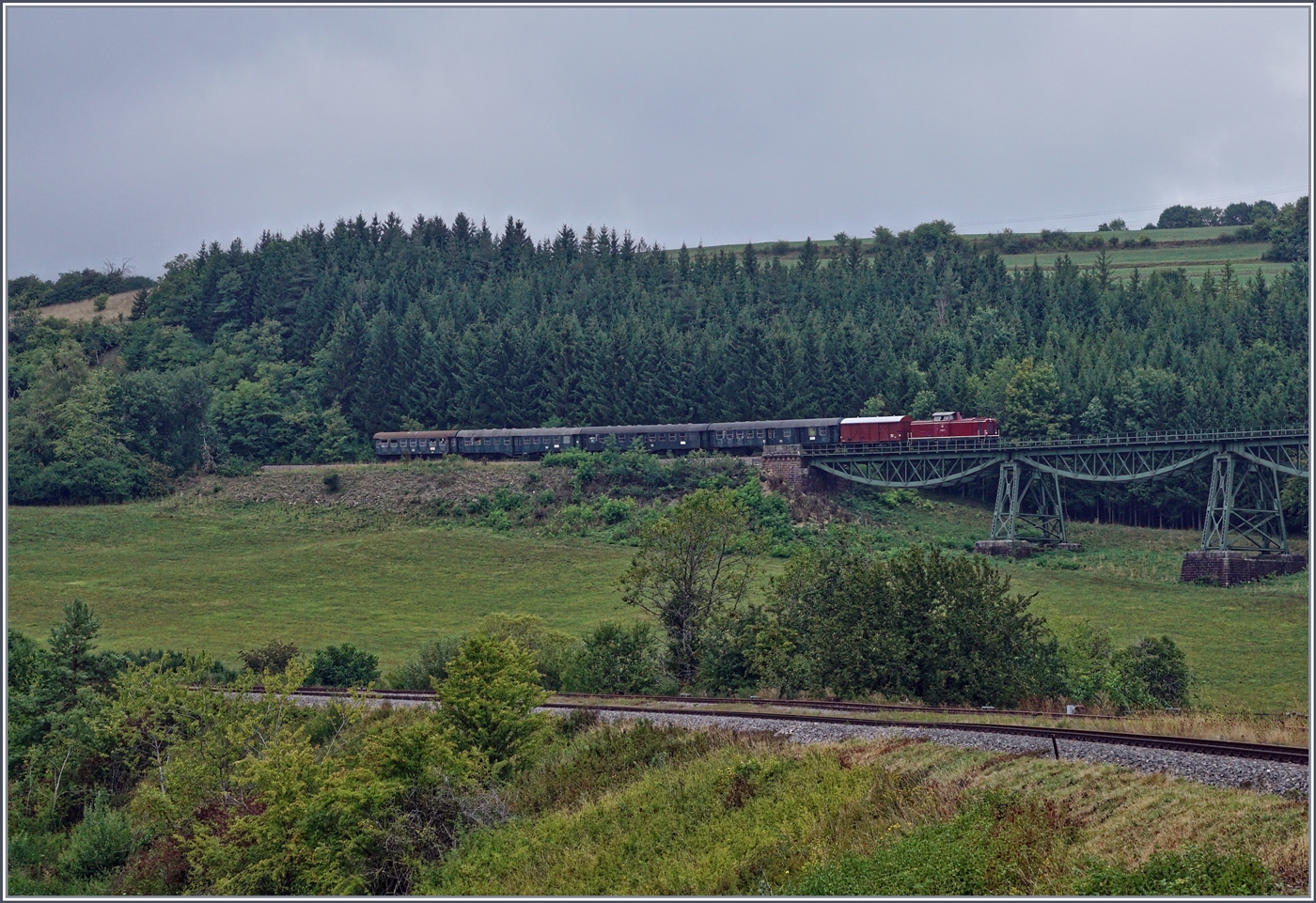 Die Strecke Wutachtal Bahn wurde aus strategischen Gr�nden so flach angelegt, dass ich mangels augenscheinlich feststellbarer Neigung den Zug erst aus der anderen Richtung erwartet habe...
Die Diesellok 211 041-9 (92 80 1211 041-9 D-NeSA) erreicht mit ihrem  Morgenzug  den 252 Meter langen Biesenbach Viadukt und wird in einigen Minuten im Bahnhof Epfenhofen, meinem Fotostandpunkt eintreffen. 

27. August 2022