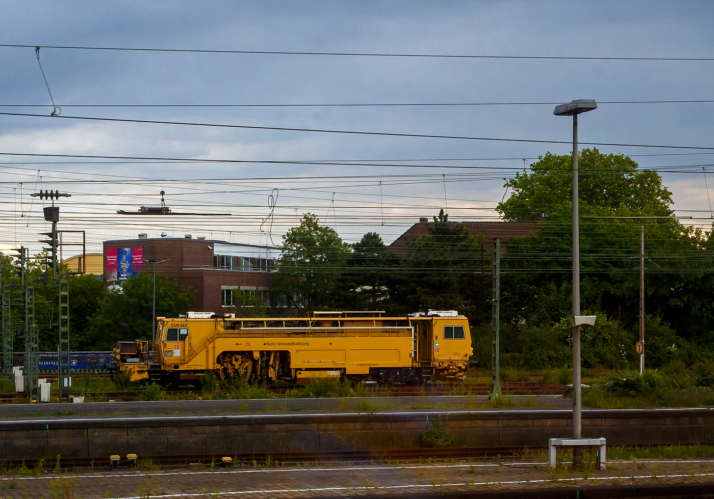 Die Universal-Stopfmaschine UNIMAT-Sprinter ESM 663 der DB Netz AG, D-DB 99 80 9122 006-5 (ex Schweres Nebenfahrzeug Nr. 97 43 52 005 17-3) ist am 31.05.2022 beim Hbf Hamm (Westf.) abgestellt: Aufnahme aus einem IC heraus. 

Der Unimat-Sprinter ist eine von Plasser und Theurer entwickelte Stopfmaschine für Gleise, Weichen und Kreuzungen, speziell konzipiert für die rasche und präzise Behebung von Einzelfehlern. Daher auch die Abkürzung ESM = EinzelfehlerStopfMaschine. Diese hier wurde 2000 von Plasser & Theurer in Linz (A) unter der Fabriknummer 1168 gebaut.
