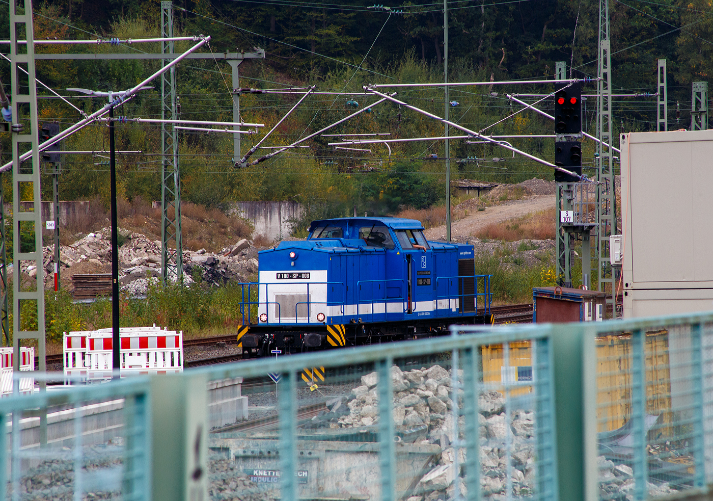 Die V 100-SP-008 / 203 128-4 (92 80 1203 128-4 D-SLG) der SLG Spitzke Logistik GmbH, ex DR 110 529-5, ex DR 112 529-3, ex DR 202 529-4, ex DB 202 529-4, rangiert am 30 September 2025 im Bahnhof Betzdorf/Sieg.

Die V 100.1 wurde 1973 von LEW (VEB Lokomotivbau Elektrotechnische Werke „Hans Beimler“ Hennigsdorf) unter der Fabriknummer 13568 gebaut und an die DR als 110 529-5 ausgeliefert. Der Umbau in DR 112 529-3 erfolgte 1985, eine Umzeichnung in 202 529-4 erfolgte 1992 und 1994 ging sie dann mit in die DB über. Die z-Stellung und Ausmusterung erfolgten 1997/1998. Dann ging sie zur SFZ - Schienenfahrzeugzentrum Stendal, ab 01.11.2002 ALS - ALSTOM Lokomotiven Service GmbH, dort wurde sie auch 
gemäß Umbaukonzept BR 203.1 umgebaut. Seit dem 20.07.2007 fährt sie nun für die SLG - Spitzke Logistik GmbH in Großbeeren als V 100-SP-008 (80 1203 128-4 D-SLG).

TECHNISCHE DATEN:
Spurweite: 1.435 mm (Normalspur)
Achsanordnung: B'B' 
Länge über Puffer: 14.240 mm
Radsatzabstand im Drehgestell: 2.300 mm
Drehzapfenabstand: 7.000 mm
Kleinster befahrbarer Gleisbogenradius: 100 m
Dienstgewicht: 68 t
Leistungsübertragung: dieselhydraulisch
Höchstgeschwindigkeit: 100 km/h
Kleinste Dauerfahrgeschwindigkeit: 11,1 km/h

Motortyp: Caterpillar 3512 B DI-TA
Motorbauart: 12-Zylinder-Dieselmotor mit Direkteinspritzung, Abgasturbolader und Ladeluftkühlung
Motorleitung: 1.305 kW (1.775 PS) bei 1.600 U/min
Hubraum: 51,8 l (Bohrung-Ø 170 x Hub 190 mm)
Motorgewicht: 6.537 kg
Getriebe: Voith Strömungsgetriebe GSR 30/5,7
Betriebsstoffvorräte: 2.500 l (Dieselkraftstoff)
Bremse: Klotzbremse, KE-GP m. Z
