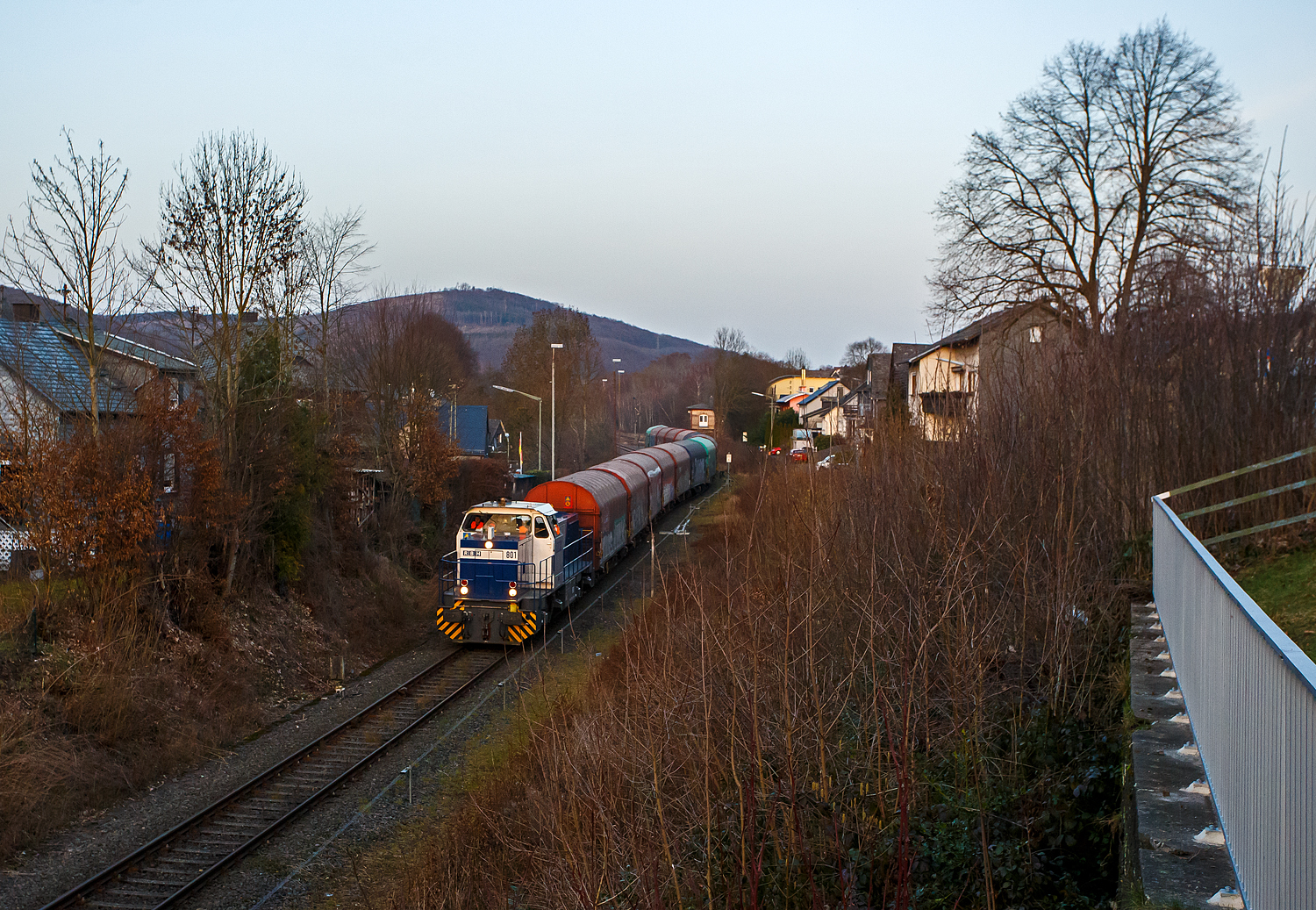 Die zurzeit an die KSW (Kreisbahn Siegen-Wittgenstein) vermietete RBH 801 / 275 801-5 (98 80 0275 801-5 D-RBH), eine MaK G 1206 der RBH - RAG Bahn und Hafen GmbH (Gladbeck), fährt am 26 Februar 2026, mit einem Übergabegüterzug (leere Wagen), von Herdorf via Betzdorf nach Kreuztal.

Die MaK G 1206 wurde 1997 von der Siemens Schienenfahrzeugtechnik (SFT) in Kiel-Friedrichsort unter der Fabriknummer 1000900 gebaut und an die damalige RAG - Ruhrkohle AG, RAG Bahn- und Hafenbetriebe in Gladbeck als RAG 802 ausgeliefert. Sie war die erste gebaute Lok des erfolgreichen Typs G 1206 aus dem 3. Typenprogramm. Im Jahr 2004 erfolgte die Umfirmierung der RAG in RAG Bahn und Hafen GmbH (RBH) und nach der Übernahme durch die DB Schenker Rail Deutschland AG (heute DB Cargo) erfolgte 2006 die Umfirmierung in RBH Logistics GmbH.
