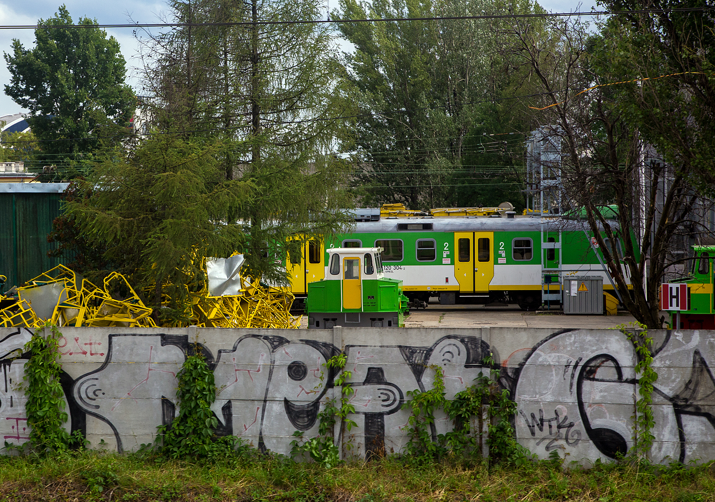 Ein Akkuschleppfahrzeug ASF EL 16 der Koleje Mazowieckie (Masowische Eisenbahnen) am 25 Juni 2017 im Depot Warszawa -Ochota (Warschau), aufgenommen aus einem Zug. Rechts versteckt sich noch ein weiteres ASF.

Dieses ASF der ehemaligen DR Baureihe EL 16 wurden in den 1970/80er Jahren von LEW (VEB Lokomotivbau Elektrotechnische Werke „Hans Beimler“, Hennigsdorf) gebaut und auch einige nach Polen an die polnische Staatsbahn PKP geliefert. In Deutschland werden sie heute unter der Baureihe 383 gef�hrt.

Die Akkuschleppfahrzeuge (ASF) der Baureihe EL 16 sind kleine, schienengebundene, batterie-elektrisch angetriebene Schleppfahrzeuge f�r den innerbetrieblichen Rangier- und Verschiebedienst.
