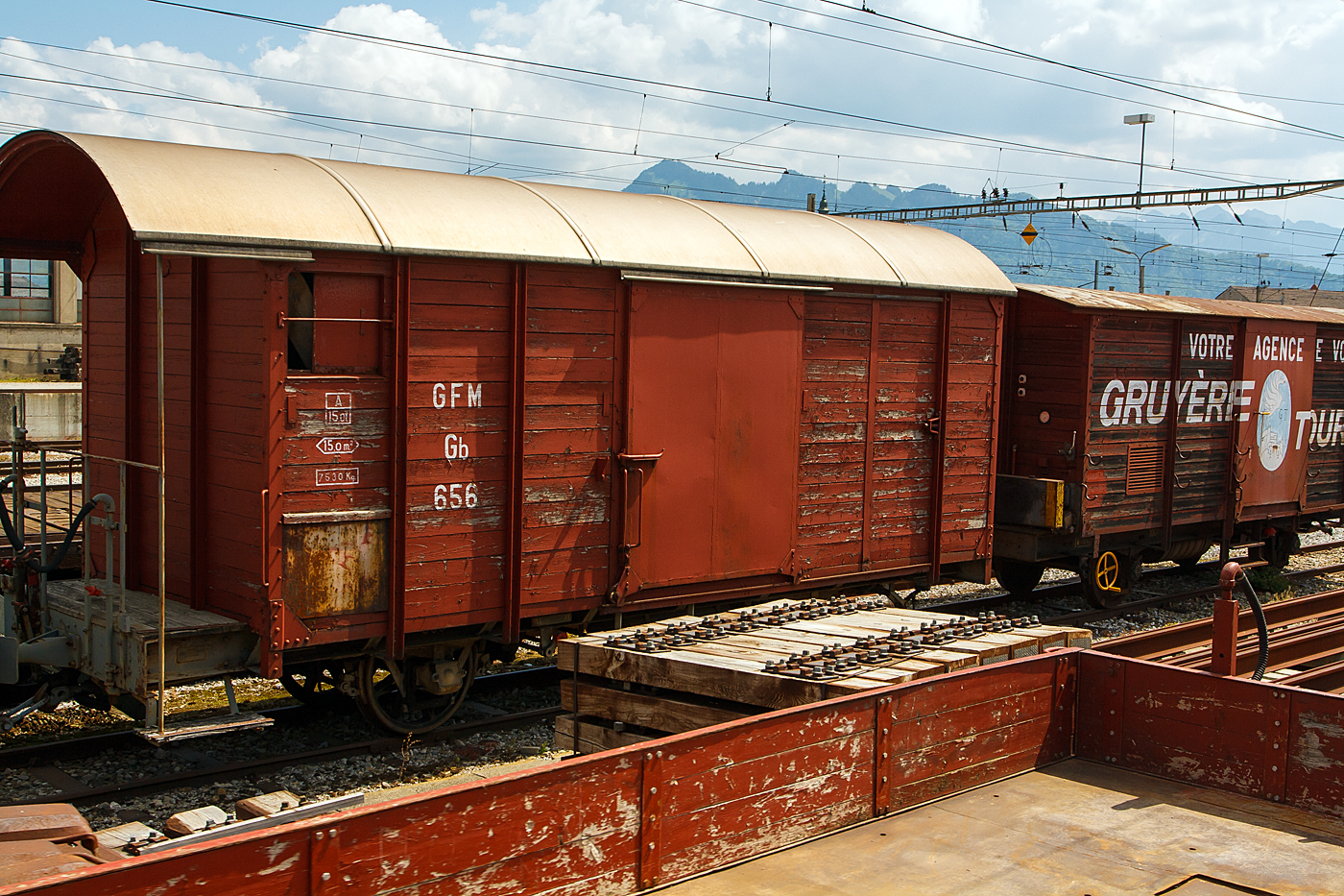 Gedeckter zweiachsiger Schmalspur-G�terwagen GFM Gb 656 mit offener Bremserplattform, abgestellt am 28.05.2012 beim Bahnhof Bulle. Davor non ein weiterer Wagen. Das Bild entstand aus einem Zug heraus. Die ehemalige GMF (Chemins de fer fribourgeois Gruy�re–Fribourg–Morat) fusionierte zum 01.01.2000 mit der Transport en commun de Fribourg (TF) zu den Freiburgischen Verkehrsbetrieben (TPF). Dabei absorbierte die GFM die TF und gab sich den neuen Namen TPF.

TECHNISCHE DATEN (laut Anschriften):
Spurweite: 1.000 mm (Meterspur)
Anzahl der Achsen: 2
Eigengewicht: 7.530 kg
Ladefl�che: 15 m�
Max. Zuladung: 15 t
