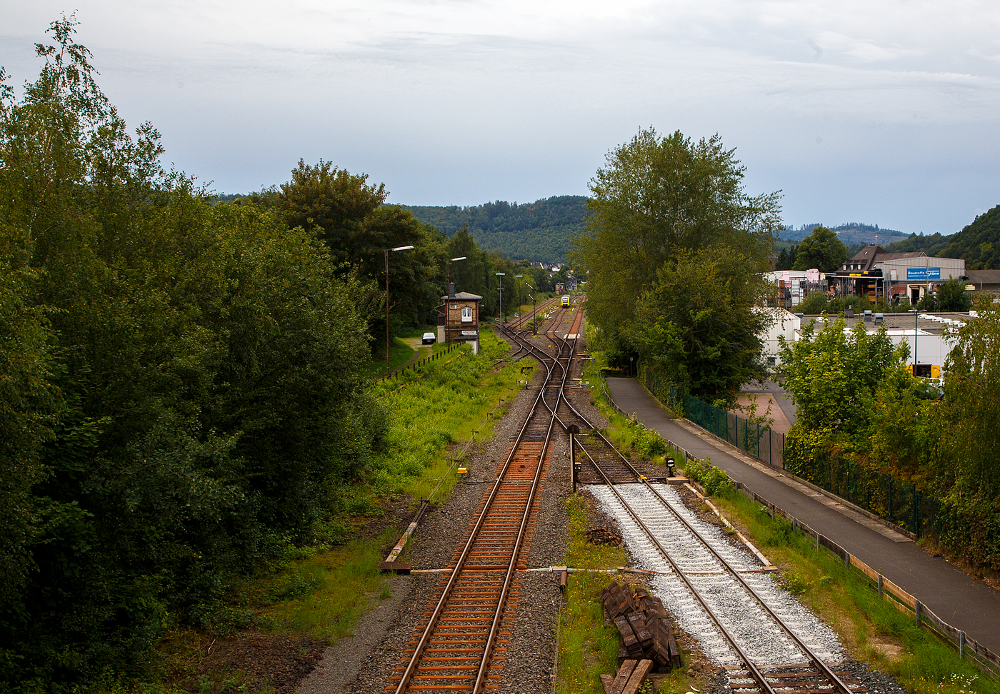 Herdorf 24.08.2023, blick von „Achenbachs Brücke“ auf den Bahnhofsbereich. Der VT 263 (95 80 0648 163-3 D-HEB / 95 80 0648 663-2 D-HEB) ein Alstom Coradia LINT 41 der HLB (Hessische Landesbahn), verlässt als RB 96 „Hellertalbahn“ (Betzdorf – Neunkirchen/Siegerland) den Bahnhof. 

Links die beiden aktiven Stellwerke, vorne das Weichenwärter Stellwerk Herdorf Ost (Ho) und hinten das Fahrdienstleiter Stellwerk Herdorf Hf). 

Rechts die Anschlussstelle zum Rangierbahnhof der KSW (Kreisbahn Siegen-Wittgenstein), Betriebsstätte FGE -Freien Grunder Eisenbahn (KSW NE447 / DB-Nr. 9275). Man kann es sehen, die ersten Meter Gleis ab der Gleissperre hat die KSW erneuern lassen.