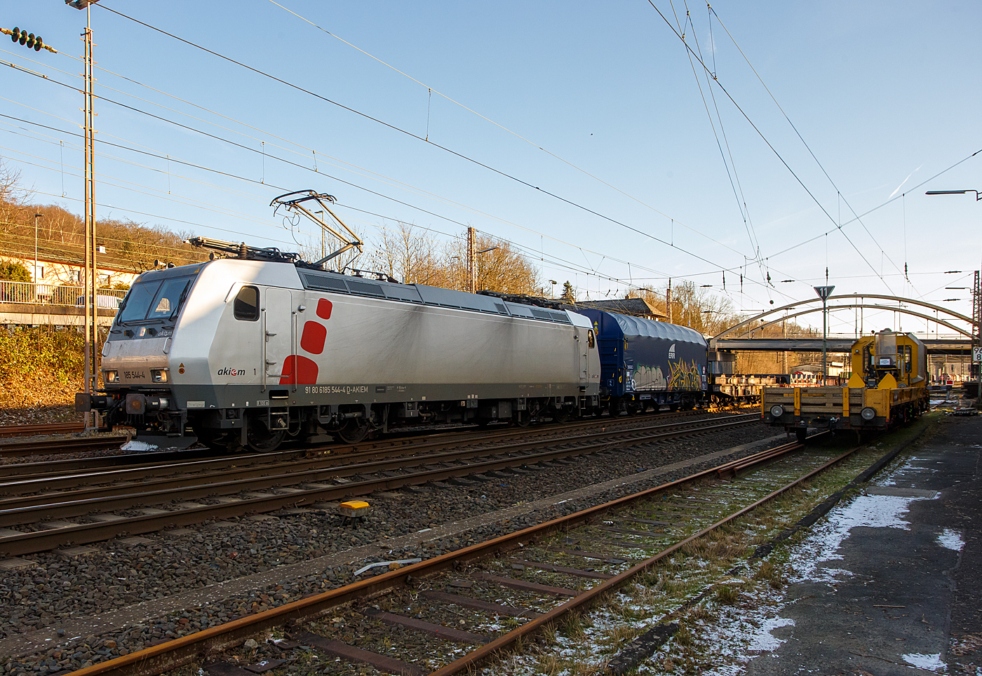 Heute am 8 Januar 2024 fegte ein bitter kalter Wind, aber endlich kam nochmal die Sonne hervor, so fuhren wir trotz der Bauerndemos nach Kreuztal, zudem ist ab morgen wegen dem GDL-Streik der Bahnverkehr lahm gelegt. Wir hatten den richtigen Weg gewählt und kamen zügig hin und zurück.

Die mit DACH-Zulassung (Deutschland, Österreich und Schweiz) an die DB Cargo AG vermietete Akiem 185 544-4 (91 80 6185 544-4 D-AKIEM), ex MRCE Dispolok (91 80 6185 544-4 D-DISPO), fährt mit einem Übergabezug (leere Coil-Wagen) vom Rbf Kreuztal in Richtung Hagen los. 

Die TRAXX F140 AC1 wurde 2005 von Bombardier Transportation GmbH in Kassel unter der Fabriknummer 33729 gebaut und an die MRCE - Mitsui Rail Capital Europe geliefert. An die AKIEM SAS wurde sie 2023 verkauft. Sie hat die Zulassungen für Deutschland, Österreich und die Schweiz (D/A/CH).
