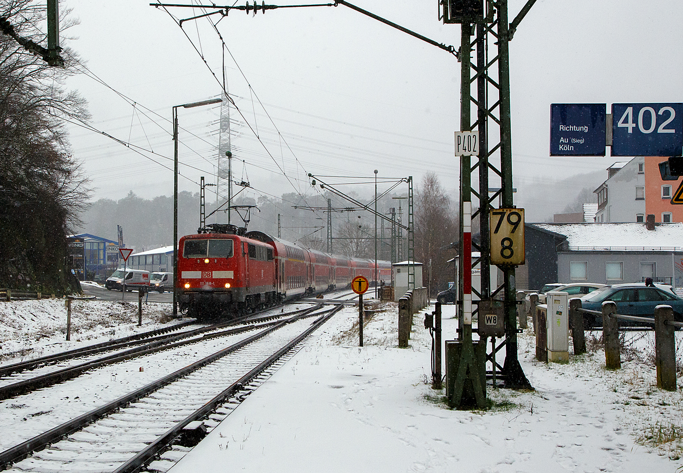 Heute hat es etwas geschneit und es schneit noch.... 
Die 111 168-1 (91 80 6111 168-1 D-DB) der DB Regio NRW rauscht am 19.01.2023 mit dem RE 9 rsx - Rhein-Sieg-Express (Aachen – Köln – Siegen), etwas verspätet durch den Bahnhof Scheuerfeld (Sieg) in Richtung Betzdorf.

Die Lok wurde 1980 von Henschel & Sohn in Kassel unter der Fabriknummer 32441 gebaut. Aktuell wird sie DB Gebrauchtzug am Markt zum Kauf angeboten.