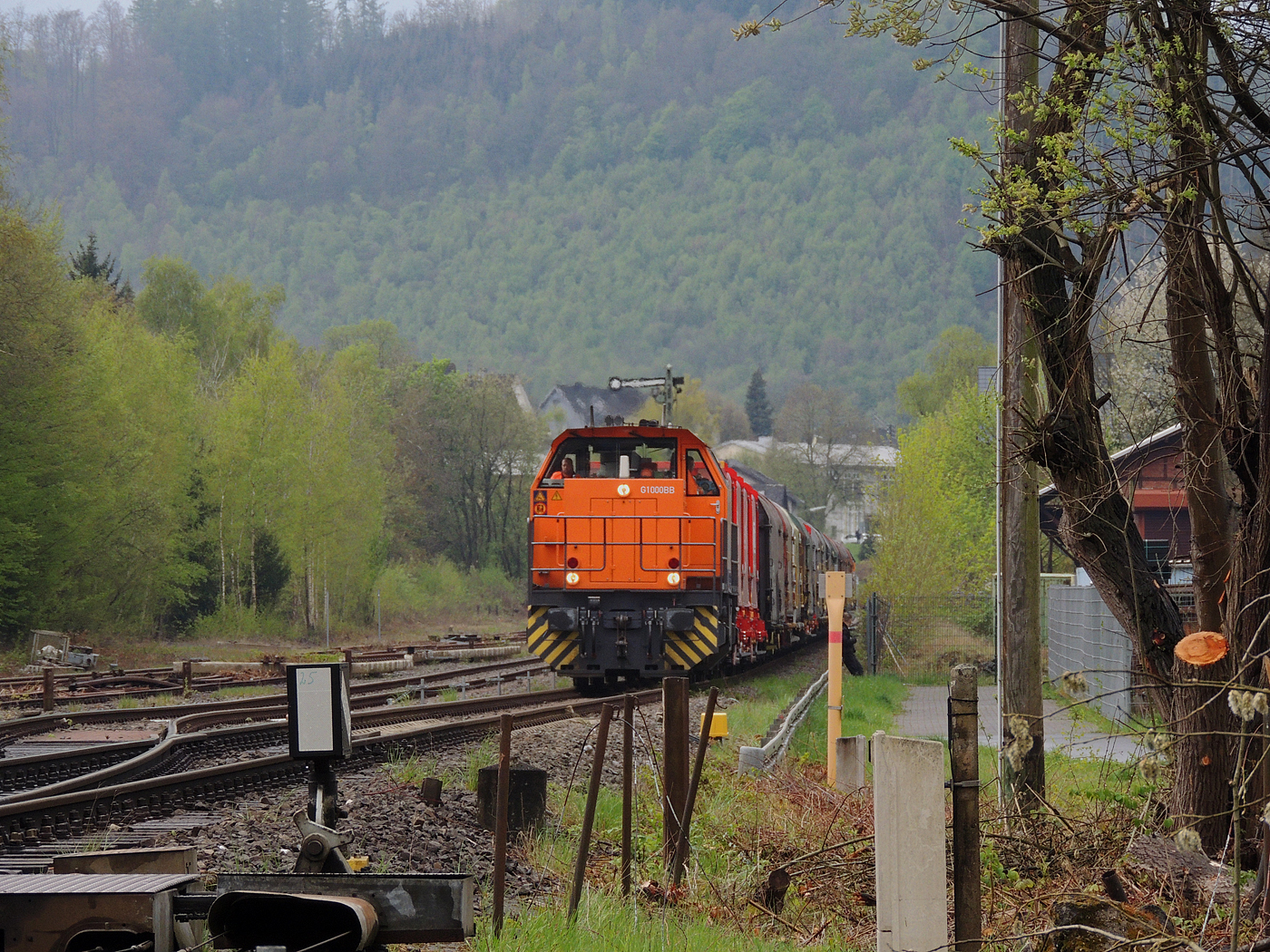 Hochbetrieb in Herdorf am 23 April 2025: 
Durch die vergangenen Osterfeiertage braucht es wohl wieder Nachschub. Die KSW (Kreisbahn Siegen-Wittgenstein) kommt im Sandwich mit einem sehr langen und somit schweren Coilzug, von via Betzdorf/Sieg kommend in Herdorf an. Gleich drauf geht es auf den KSW-Rangierbahnhof (Betriebsstätte FGE - Freien Grunder Eisenbahn). Übrigens die neuen m²-Güterwagen/Tragwagen der Gattung Uas 224.2 für Coiltransporte der DB Cargo AG sind hier immer mehr anzutreffen.

Vorne als Zuglok die KSW 44 (92 80 1271 004-4 D-KSW) eine MaK G 1000 BB und hinten nachschiebend die KSW 47 (92 80 1271 027-5 D-KSW), ex D 2 der HFM, eine Vossloh G 1000 BB.

Im Rbf wird der Zug geteilt, da er für die Weiterfahrt sonst zu lang wäre, und die KSW 44 zieht den ersten Teil weiter zu den Schäfer Werke KG am Pfannenberg in Neunkirchen-Salchendorf. 

Später kam dann noch die KSW 43 (92 80 1273 018-2 D-KSW), die asymmetrische Vossloh G 2000 BB, mit einem langen Coilzug von Duisburg an.