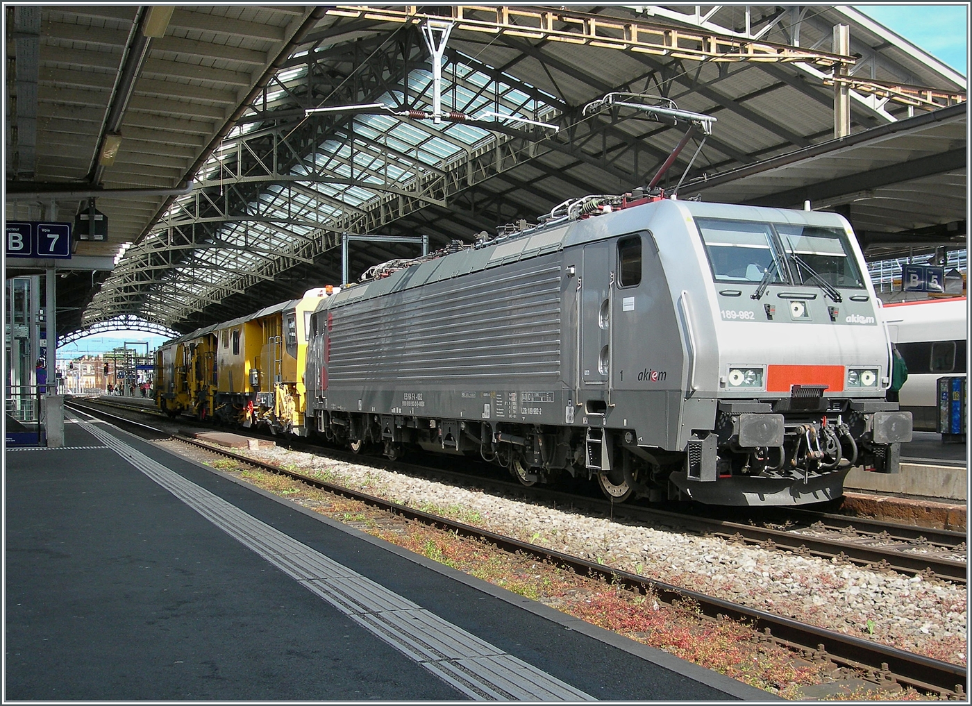 Ich staunte nicht schlecht, als die erneut die akiem 64 F4 082 (91 80 189 982-2 D-AKIEM) in Lausanne zu sehen bekam. Die Lok wartet  mit einer Gleisbaumaschine auf die baldige Weiterfahrt in Richtung Vevey. Seit der �bernahme der  Novelis -Z�ge durch DB 185 sind die ohnehin raren Eins�tze der BR 189 in der Gegend von Lausanne sehr selten geworden, so dass diese akiem 64 F4 082 (91 80 189 982-2 D-AKIEM) ein nicht allt�gliches Motiv darstellt. 24. Mai 2025