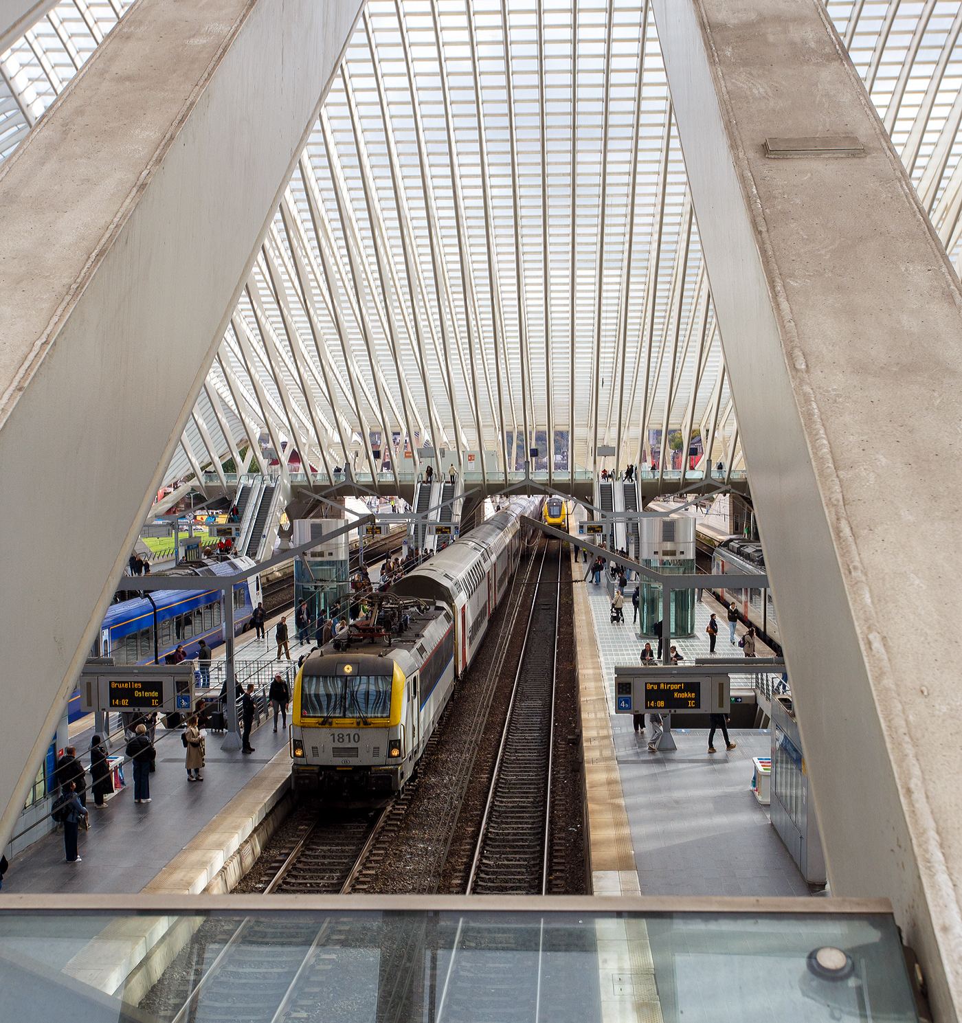 Im Sandwich zweier SNCB/NMBS der Serie 18, geführt von der HLE 1810 und einer schiebenden HLE 18er, fährt der IC 536 (Eupen - Lüttich/Liège-Guillemins - Brüssel – Gent – Brügge – Ostende), am 21 Oktober 2025 in den Bahnhof Liège Guillemins (Lüttich-Guillemins) ein. Zwischen den beiden Lok vom Typ SIEMENS EuroSprinter ES60U3 waren 6 SNCB M7-Doppelstock-TWINDEXX-Wagen, 2 SNCB Reisezugwagen Typ I10 B sowie 2 SNCB Reisezugwagen Typ I11 B.