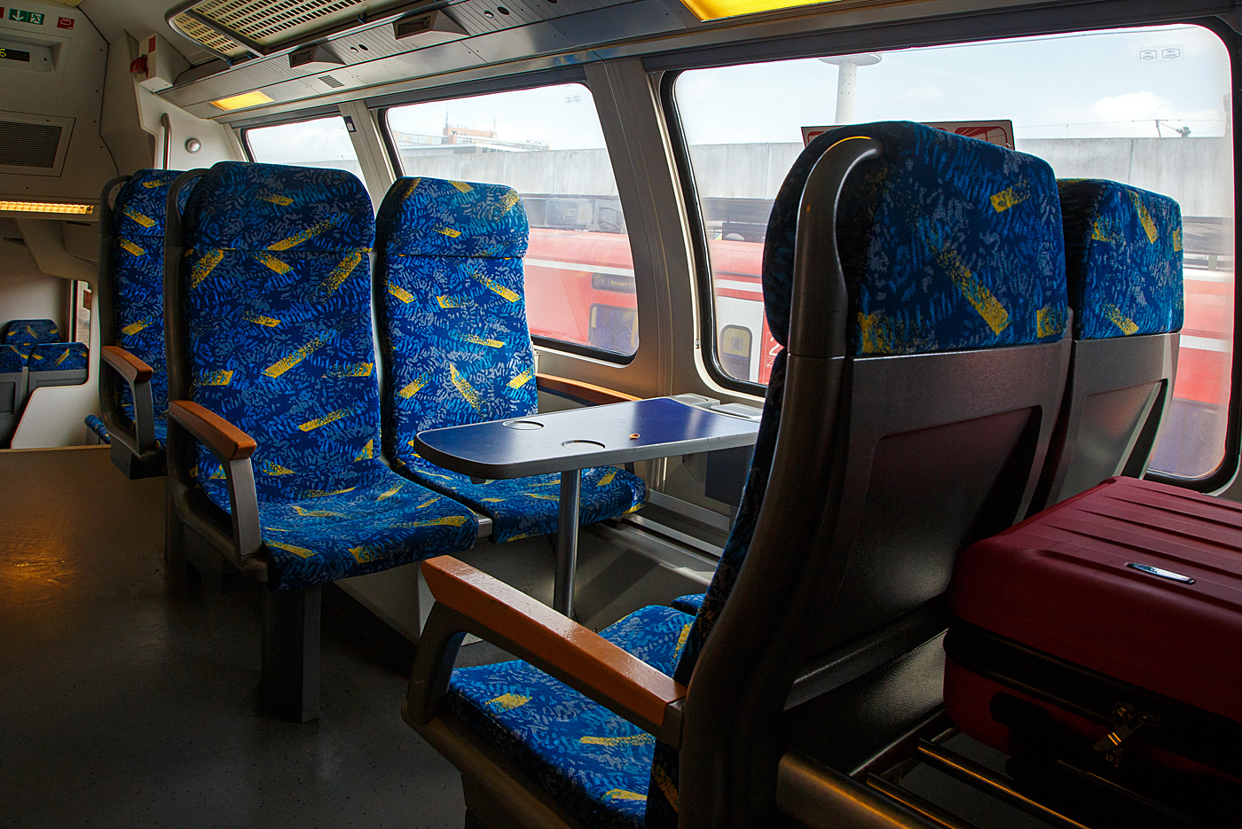 Innenraum /Interieur im zweite Klasse Großraumabteil im Oberdeck eines Metronom-Doppelstockwagen der vierten Generation (der Bauart „Görlitz“), mit einer Vierersitzgruppe mit Tisch (Vis-à-vis), hier am 14 Mai 2022 (im RE 3) bei Hannover. Auch für Gepäckablage ist gut gesorgt.
