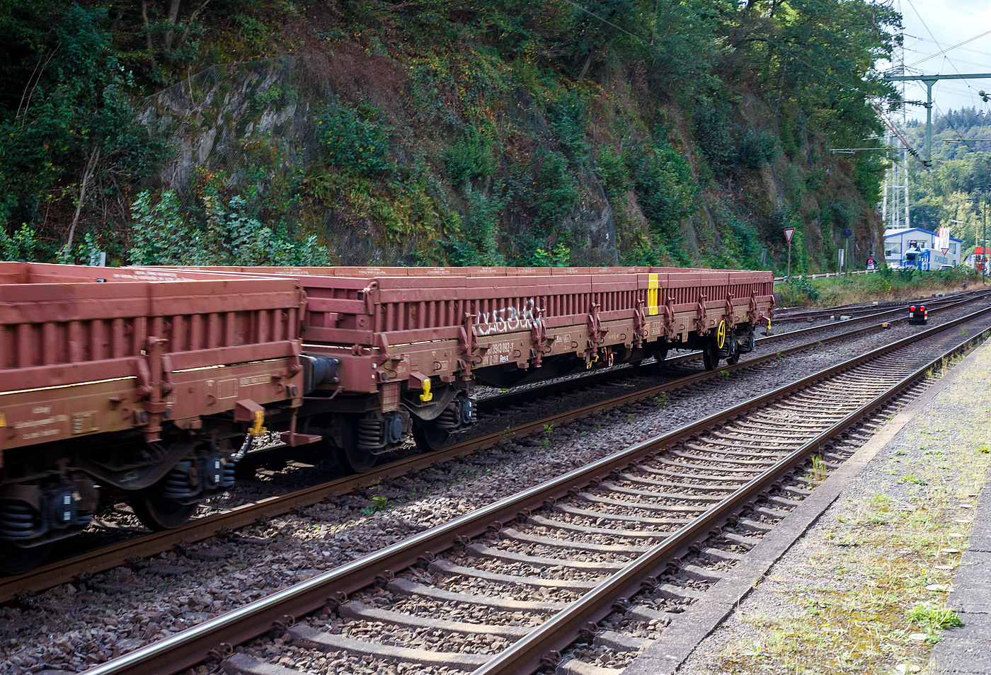 Leerer vierachsiger  Drehgestell-Flachwagen (Niederbordwagen) mit Seitenborden, Stirnw�nden (Stahl-Bordw�nden) und Stahlfu�boden, 31 80 3944 092-7 D-DB, der Gattung Res-x 679.1, der DB Cargo AG, am 11 September 2024 im Zugverband (Zugschluss) bei einer Zugdurchfahrt in Scheuerfeld (Sieg).

Der Wagen ist f�r den Transport von schweren Sch�ttg�tern vorgesehen. Der Wagen ist in Ganzstahlbauweise unter Verwendung von Profilen und abgekanteten Blechen hergestellt. Als Material f�r diese Schwei�konstruktion wird vor allem St 52-3 und St 38 verwendet. Der Fu�boden besteht aus 8 mm dickem Riffelblech und wird an der Stirnseite des Wagens durch ein U-Profil und an den L�ngsseiten durch einen Flachstahl begrenzt.

Der Wagen ist an jedem Kopfst�ck mit zwei Fallrungen ausger�stet. Um die Seitenwandklappen in ihrer senkrechten Lage festzulegen, sind an jeder Wagenl�ngsseite 8 verst�rkte Gleitrungen angeordnet. Der Wagen besitzt keine Ladeschwellen. Der Wagen kann auch mit heruntergeklappten Seitenw�nden ohne Ladema��berschreitung bef�rdert werden. Der Wagen besitzt eine vom Boden aus bedienbare Feststellbremse, die auf ein Drehgestell wirkt.

TECHNISCHE DATEN:
Umgebaut aus: Res 676 im Jahr 2010
Spurweite: 1.435 mm
L�nge �ber Puffer: 19.900 mm
Drehzapfenabstand: 14.860 mm
Achsabstand im Drehgestell: 1.800 mm
Bauart der Drehgestelle: BA 853
Ladebreite: 2.530 mm
L�nge der Ladefl�che: 18.500 mm
Ladefl�che: 46,8 m�
H�chstgeschwindigkeit: 120 km/h / 100 km/h (beladen)
Eigengewicht: 25.000 kg
Maximale Ladegewicht: 55,0 t (ab Streckenklasse C) 
Kleinster bef. Gleisbogenradius: 35 m
Bremse: KE-GP (LL)
Handbremse: auf ein Drehgestell
Intern. Verwendungsf�higkeit: RIV
