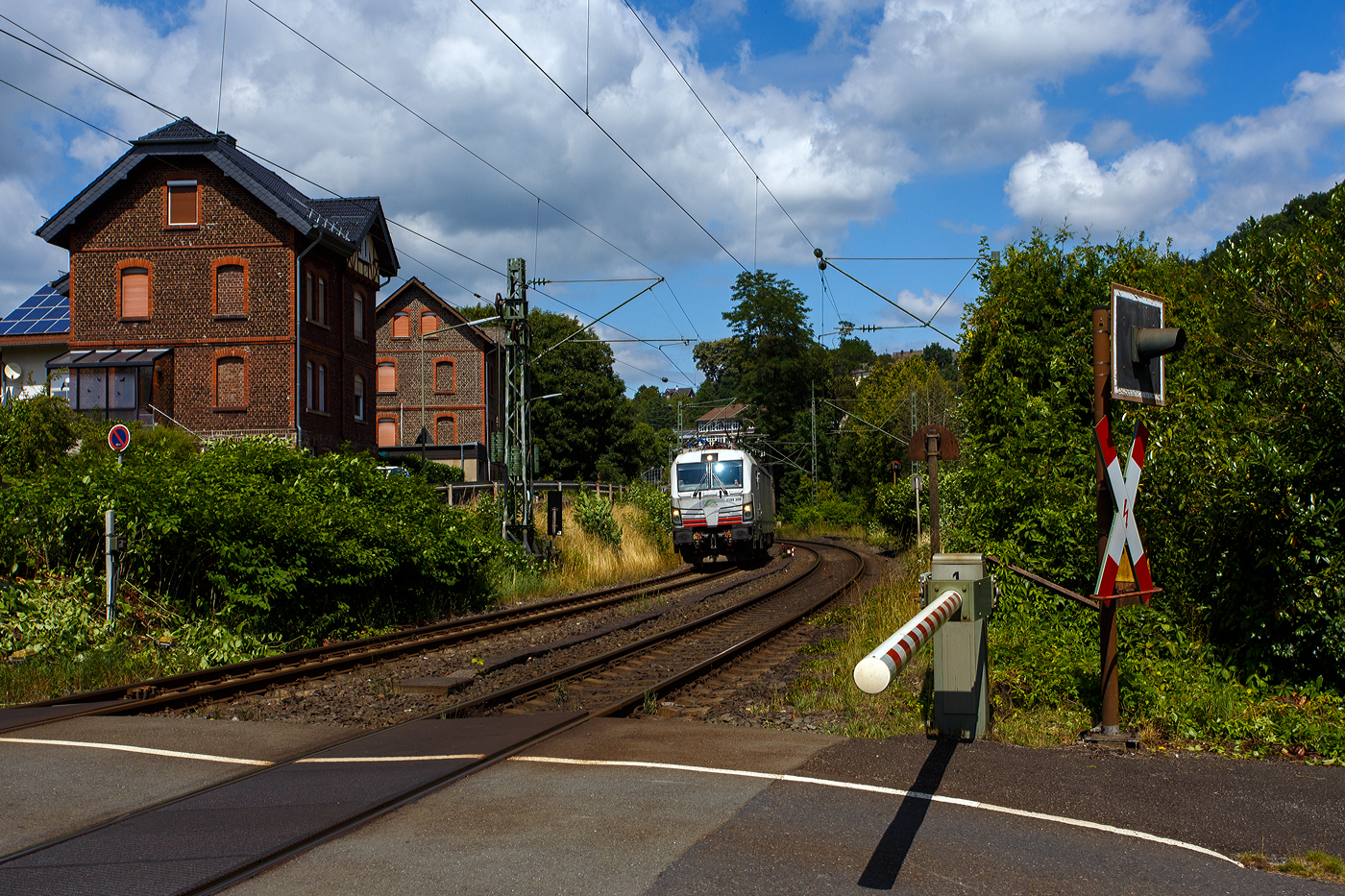 Meine erste SIEMENS Vectron mit 7 vor der 193, sowie eine ersten eigenen SIEMENS Vectron der TX Logistik AG, bisher hatte diese nur Loks angemietet. Die recht neue weiße TXL 7193 309 „Connected to Nature“ (91 80 7193 309-0 D-TXL) der TXL - TX Logistik AG (Troisdorf) fährt am 17 Juli 2025, mit einem KLV-Zug, durch Kirchen (Sieg), hier beim Bü km 121,192 in Richtung Betzdorf bzw. Köln.

Nochmals einen lieben Gruß an den netten Lokführer zurück.

Die SIEMENS Vectron MS (X4E) wurde 2024 von Siemens Mobility in München-Allach unter der Fabriknummer 23562 gebaut und am 03.01.2025 an die TXL ausgeliefert. Die mit 6.400 kW konzipierte Mehrsystemlok ist in der Variante A22-11i ausgeführt und hat so die und hat so die Zulassungen und entspr. Länderpakete für Deutschland, Österreich, Schweiz, Italien und die Niederlande (D / A / CH / I / NL).

Über TX Logistik AG
TX Logistik wurde 1999 als privates Eisenbahnverkehrsunternehmen gegründet und bietet mit Verbindungen in elf Ländern ein leistungsfähiges europäisches Netzwerk. Das Unternehmen verfügt über Tochtergesellschaften in der Schweiz, Österreich, Dänemark und Schweden sowie eine lokale Präsenz in Italien. In den Geschäftsbereichen Intermodal und Rail Freight entwickelt TX Logistik umfassende Schienenlösungen für kontinentale und maritime Verkehre sowie maßgeschneiderte Konzepte für konventionelle Fracht. Mit 650 Mitarbeitern und 8,6 Milliarden gefahrenen Tonnenkilometern erwirtschaftete das Unternehmen 2021 einen Jahresumsatz von 253 Millionen Euro. Seit Januar 2017 gehört TX Logistik zu 100 Prozent der Mercitalia Logistics S.p.A., einer Tochtergesellschaft der FS - Ferrovie dello Stato Italiane. Mittlerweile gehört das Unternehmen mit zu den Größten für den Schienengüterverkehr in Europa.

Das Unternehmen bietet den ganzen Umfang an Schienengüterverkehr, inklusive Containertransport und kombiniertem Verkehr an. Wichtigste Transportstrecken sind von den Häfen Hamburg, Bremerhaven, Rotterdam und Antwerpen nach Süddeutschland, Schweiz, Österreich und Italien.

TX Logistik setzt nun auf eigene Vectron Loks:
Anfang Oktober 2024 hat die TX Logistik AG ersten drei von 40 modernen Vectron-Lokomotiven des Herstellers Siemens Mobility aufs Gleis gesetzt, die das zur Mercitalia Logistics (FS Italiane Group) gehörende Schienenlogistikunternehmen im Mai 2023 bestellt hatte. Die Erweiterung der Fahrzeugflotte ist für TX Logistik eine wichtige Voraussetzung, um im intermodalen und grenzüberschreitenden Schienengüterverkehr weiter zu wachsen. Die neuen Lokomotiven werden vor allem auf dem Brenner- und dem Schweiz-Korridor eingesetzt, den strategisch wichtigen Nord-Süd-Achsen in Europa.

Beide Korridore sind stark frequentiert und stellen hohe Anforderungen an die eingesetzten Lokomotiven – von der Zugkraft über die Stabilität bis hin zur grenzüberschreitenden Systemkompatibilität. TX Logistik hat dazu die Maschinen mit verschiedenen Länderpaketen bestellt. 20 Vectron erhalten das Länderpaket für den Betrieb in Deutschland, Österreich, Schweiz, Italien und den Niederlanden (D-A-CH-I-NL) und sollen bis Anfang 2025 übergeben werden. Die Auslieferung der 20 Lokomotiven mit der Ausstattung für den deutsch-österreichisch-italienischen Korridor (D-A-I) soll bis zum Jahresende 2025 erfolgen.

Die Entscheidung für den Kauf der Vectron-Lokomotiven unterstreicht zugleich das Bestreben von TX Logistik, Schienengüterverkehre als umweltfreundliche und effiziente Alternative zum Straßentransport weiter voranzutreiben. Um dies zu unterstreichen und gleichzeitig für den Einstieg in den intermodalen Transport zu werben, hat die erste der drei Vectrons, die im Zughotel in Braunschweig übergeben wurden, eine spezielle Lok-Beklebung mit dem Schriftzug „Start now (Nature). Driven by Green Passion“ erhalten.

Die neuen Loks bieten mit ihrer Flexibilität und Leistungsfähigkeit ideale technische Voraussetzungen, um den steigenden Anforderungen des europäischen Güterverkehrs gerecht zu werden. Mit der modernen Vectron-Flotte, so TX Logistik, sei man mittelfristig nun in der Lage, die Kapazitäten auf dem Brenner- und dem Schweiz-Korridor deutlich zu erhöhen sowie die Effizienz und Zuverlässigkeit im Schienengüterverkehr weiter zu verbessern.
