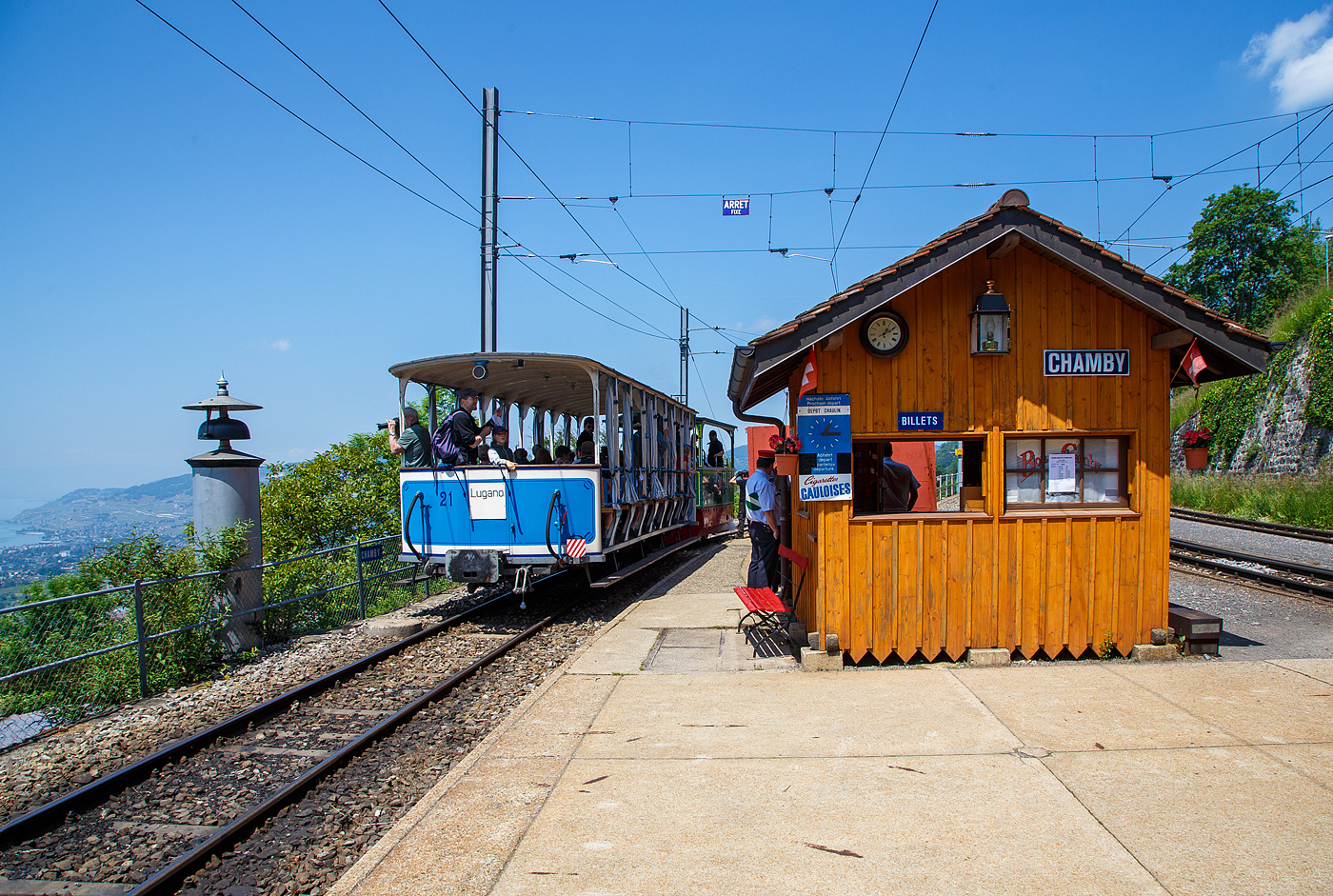Pfingsten 2023 (Samstag 27. bis Montag 29. Mai 2023) fand bei der Museumsbahn Blonay–Chamby das Schweizer Dampffestival 2023 / Festival suisse de la Vapeur 2023 statt.

Bahnhof Chamby �ber dem Genfersee am 27. Mai 2023, die G 2/2 Nr. 4 (020T) Krauss-Kastendampflok (Tramlok), ex Rimini-Novalfeltria (I), der Museumsbahn Blonay–Chamby, hat gerade mit dem vorgestellten zweiachsigen haboffenen Personenwagen (Sommerwagen) ex LCD C 21 den Bahnhof erreicht. 

Links ein L�utewerk, der Zug steht auf der Strecke (KBS 115) Blonay–Chamby, sie wird in der Sommersaison von der Museumsbahn BC betrieben und befahren, geh�rt aber der Transports Montreux–Vevey–Riviera (MVR, ex CEV). Recht der Ticketschalter der Museumsbahn und ganz rechts die (Montreux–Berner Oberland-Bahn) MOB Strecke (KBS 120) Montreux–Montbovon–Zweisimmen, 

Der LCD C2 21 mit dem Spitznamen Giardiniera (Gartenhaus) ist einer der beiden urspr�nglichen erhaltenen aber unterschiedlichen zweiachsigen Personenwagen der Lugano-Cadro-Dino-Bahn. Er charakterisiert sich durch die offene Bauweise als Sommerwagen mit durchgehenden in der Fahrtrichtung umlegbaren R�cklehnen der Holzb�nken, im Gegensatz zum C2 11, bei dem es sich um einen geschlossenen Personenwagen mit festen Sitzb�nken handelt.

Die von Anfang an elektrisch betriebene Lugano-Cadro-Dino-Bahn, abgek�rzt LCD, hatte bei ihrer Betriebser�ffnung 1911 gerade sieben Fahrzeuge, vier baugleiche Triebwagen und drei unterschiedliche Personen- und G�terwagen.1943 wurden zwei zus�tzliche Sitzb�nke auf den damals noch offenen Endplattformen eingef�gt und damit die Anzahl Sitzpl�tze erh�ht. Im Zusammenhang mit der Klassenreform 1956 wurde der Sommerwagen neu als zum B2 21 bezeichnet.

W�hrend in den L�ndern des S�dens viele Bahnen offene Fahrzeuge einsetzen, sind diese Fahrzeuge in unseren Breiten doch seltener. Neben der Basler Tram war die Lugano-Cadro-Dino-Bahn (LCD) eine der wenigen in der Schweiz, die solche Fahrzeuge einsetzte. 

Der hier vorgestellte Wagen mit dem Spitznamen „Giardiniera“ (Gartenhaus) ist prominent auf den Werbeprospekten dieser ehemaligen Bahn zu finden. An den Wochenenden nehmen viele Stadtbewohner ihre Pl�tze an Bord ein und genie�en die herrliche Aussicht auf den Luganersee, vorbei an Weinbergen und Kastanienw�ldern.Von einer touristischen Berufung in den Kinderschuhen hat sich die Eisenbahn im Laufe der Jahre im Zuge ihrer Entwicklung zu einem Vorortdienst entwickelt. Da es immer h�ufiger zu Konflikten mit dem Autoverkehr kam, wurde der st�dtische Endpunkt der Bahn 1967 vor die Tore der Stadt verlegt. Nachdem dieser Abschnitt, der ihn mit dem Stadtzentrum und der Anlegestelle verband, abgetrennt wurde, nahm seine touristische Attraktivit�t stark ab, was im Juni 1970 dazu f�hrte, dass die Eisenbahn durch eine Busverbindung ersetzt wurde. Die „Giardiniera“ wurde auf dem Platz des alten Bahnhofs von Tesserete, in Erinnerung an andere Tessiner Eisenbahnen, die zur gleichen Zeit verschwanden, als Denkmal abgestellt. Aber st�ndig dem Wetter ausgesetzt, sind kostspielige Wartungsarbeiten erforderlich, um es in einem gutem Zustand zu erhalten.Aus Sorge um seinen Erhalt verkaufte das Unternehmen Autolinee Regionali Luganesi, der neue Betreiber der ehemaligen Eisenbahnverbindungen der Region, diesen Wagen im Dezember 1990 an Blonay-Chamby. Er wurde dann einer umfassenden �berholung unterzogen. Die Achsen, der Boden, die Pfosten, B�nke und ihre schmiedeeisernen St�tzen, Sicherheitsbarrieren und das gesamte Blech wurden erneuert, sodass der Wagen „Giardiniera“ im Sommer 1995 seien Betrieb, mit der urspr�nglichen Bezeichnung, wieder aufnehmen konnte. Der Wagen ist mit der urspr�nglichen Mittelpufferkupplung, sowie zus�tzlich zur Vakuumbremse mit einer Druckluftbremse versehen. 2011, anl�sslich des hundertj�hrigen Bestehens des Wagens, wurde er wieder mit dem urspr�nglichen Anstrich versehen.

TECHNISCHE DATEN:
Baujahr: 1911
Hersteller: SWS Schlieren (Schweizerische Wagons- und Aufz�gefabrik AG)
Spurweite: 1.000 mm (Meterspur)
Achsanzahl: 2 
Eigengewicht: 5,1 t
Sitzpl�tze: 50 in der 3. Klasse
