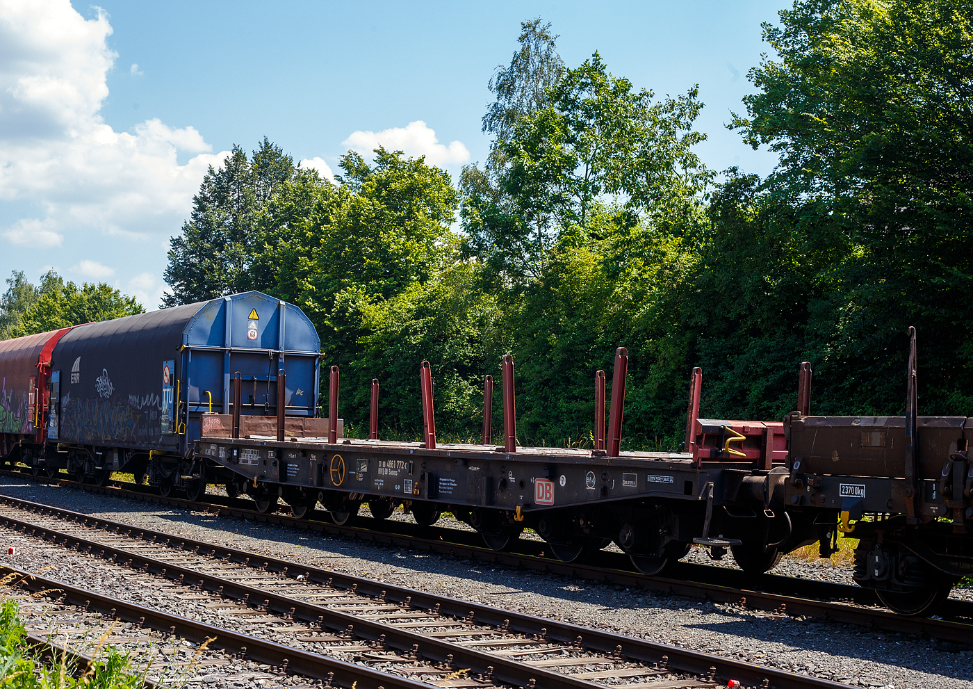 Sechsachsige Drehgestell-Flachwagen mit, mit Einsteck-Rungen, Stirnwandklappen und klappbaren Ladeschwellen, jedoch ohne Seitenwandklappen, 31 80 4861 772-0 D-DB, der Gattung Samms 710, der DB Cargo AG, abgestellt am 26 Juni 2024 im Zugverband, auf dem KSW Rbf in Herdorf (Betriebsstätte Freien Grunder Eisenbahn - NE 447).

Zwischen 1964 und 1977 beschafft die DB insgesamt 3.850 Drehgestell-Flachwagen für die Beförderung schwerer Walzprofile, Brammen, oder anderer sperriger Güter, sowie schwerer Kettenfahrzeuge.

Der Wagen hat pro Längsseite sechs Einsteckrungen und je zwei Fallrungen an den Stirnseiten, die die 435 mm hohen, umklappbaren Stirnwandklappen sichern. Im mit Kiefernbohlen bedeckten Fußboden (er kann einen Raddruck bis 5,0 Tonnen aufnehmen) sind sechs geteilte, klappbare Ladeschwellen integriert. Für die Be- und Entladung schwerer Fahrzeuge sind an den Wagenenden Stützböcke und Überfahrkonsolen vorhanden. Der Wagen dient mit aufgeklappten Ladeschwellen zur Beförderung von schweren Walzprofilen und anderen sperrigen Gütern. Die max. Tragfähigkeit der Wagen beträgt 89,5 t.

Die Wagenbrücke ist eine in Rahmenbauweise ausgeführte Schweißkonstruktion, deren Hauptbauteile aus St 52 bestehen. Die Hauptbelastungen werden von den äußeren Langträgern aus IP 550 aufgenommen. Die Pufferträger sind so ausgebildet, dass später ohne große Änderungen die AK eingebaut werden kann.

Die bodenbedienbare Feststellbremse wirkt nur auf ein Drehgestell. Der Wagen hat eine geteilte Zugeinrichtung und Hochleistungspuffer.

TECHNISCHE DATEN:
Gattung: Samms 710 (Gattungskennzahl 4861)
Spurweite: 1.435 mm (Normalspur)
Länge über Puffer: 16.400 mm
Drehzapfenabstand: 8.400 mm
Radsatzstand in den Drehgestellen: 2 x 1.700 mm = 3.400 mm
Raddurchmesser: 920 mm (neu)
Drehgestell-Bauart: 710
Ladelänge: 15.000 mm
Ladebreite: 2.560 mm
Fußbodenhöhe über SO: 1.300 mm
Ladefläche: 45,7 m²
Eigengewicht: 30.500 kg
Zuladung bei Lastgrenze S: 74,5 t (ab Streckenklasse D), DB CE 89,5 t 
Max. Geschwindigkeit: 100 km/h / 120 km/h (leer) 
Kleinster Gleisbogenhalbmesser: 80 m
Bauart der Bremse: KE-GP (LL)
Bremssohle: C 952-1 / IB116
Handbremse: Fbr
Verwendungsfähigkeit: RIV
