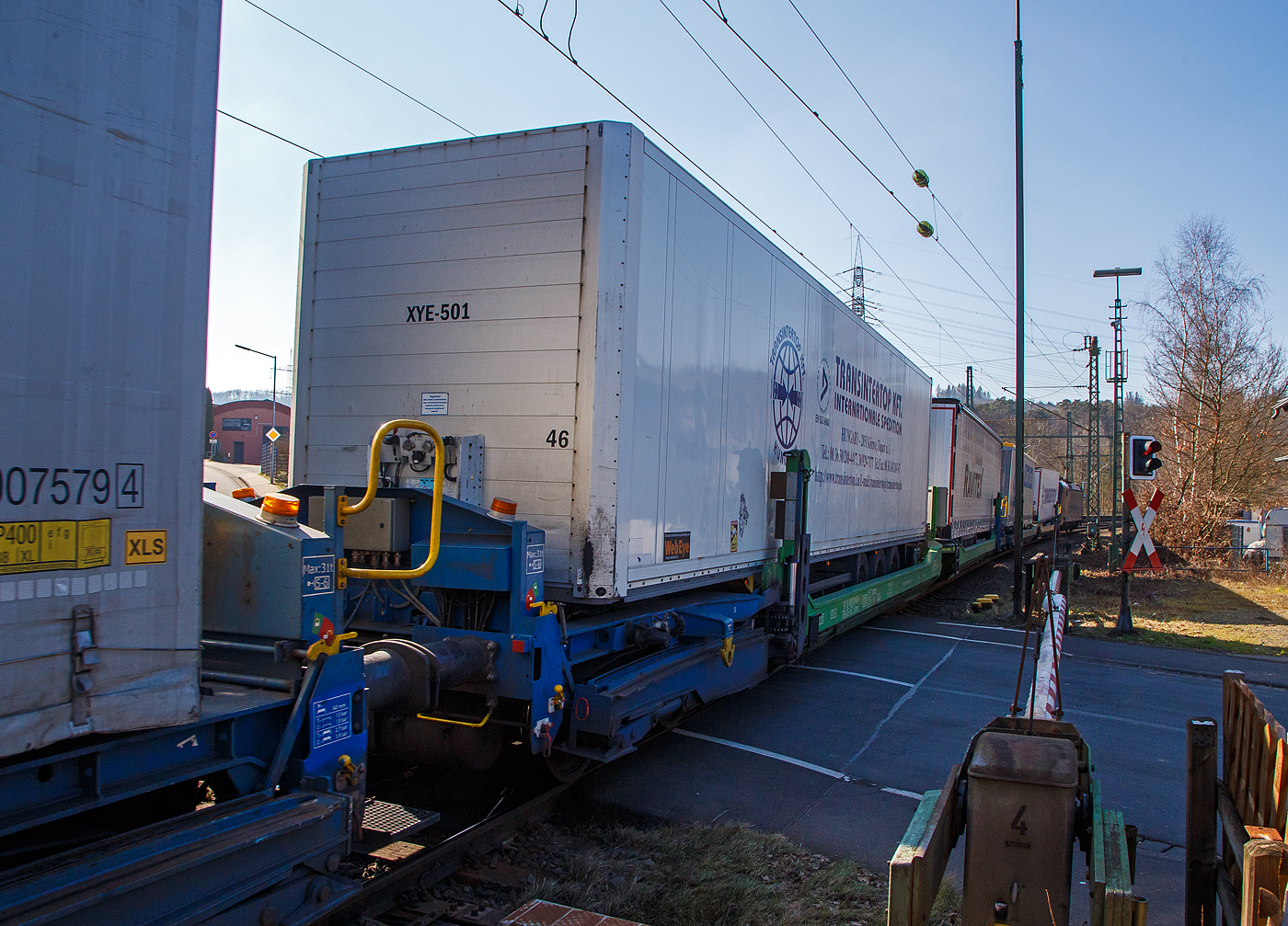 Spezieller sechsachsiger Gelenk-Taschenwagen System HELROM, 87 80 4993 016-6 D-HEL, der Gattung Sdmrs, der HELROM Trailer Rail am 03.03.2023 im Zugverband bei der Durchfahrt in Scheuerfeld (Sieg).

Der Clou bei HELROM sind neuartige Transportwaggons, die keine teuren Kran- oder Verladeeinrichtungen brauchen. Auch m�ssen die Sattelauflieger nicht kranmanipulierbar sein, das sind auch hier zu Lande die wenigsten.Dieses Megaswing-System ist ein spezieller Taschenwagen mit schwenkbaren Aufnahmewannen f�r Sattelauflieger. Hydraulikst�tzen dienen als Stabilisierung, wenn die Wanne nach links oder rechts ausschwenkt. Die Beladung der Wanne mit einem Sattelauflieger erfolgt r�ckw�rts. Nach Absatteln des Sattelaufliegers wird die Wanne angehoben und schwenkt wieder ein. Der Sattelauflieger wird leicht abgesenkt und mit dem Waggon fest verbunden, er ist nun auf dem Waggon sicher verstaut. Die Technik ist im Waggon verbaut.

TECHNISCHE DATEN:
Hersteller: G�k Yapi (T�rkei)
Spurweite: 1.435 mm
L�nge �ber Puffer: 34.230 mm
Drehzapfenabstand: 2 x 14.200 mm
Achsabstand im Drehgestellen: 1.800 mm
Laufraddurchmesser: 920 mm (neu)
Eigengewicht: 45.200 kg
Max. Zuladung bei Lastgrenze: 76,0 t (ab Streckenklasse D)
Max. Geschwindigkeit: 100 km/h (beladen) / 120 km/h (leer)
Kleinster befahrbarer Gleisbogen: R 75 m
Bremse: 2 x MH-GP-A (K)
Bremssohle: Cosid 810
Feststellbremse: Ja (aufs mittlere Drehgestell)
Intern. Verwendungsf�higkeit: TEN CW